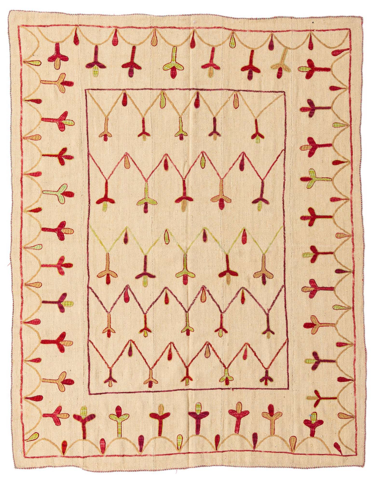 A 6x9 rectangular ivory wool flatweave rug with a tribal Suzani pattern in red, green, and gold.
