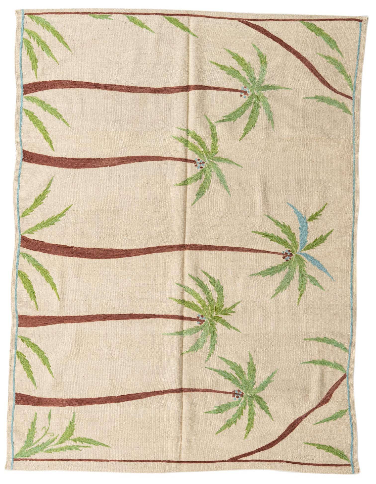 A 5x8 rectangular ivory flatweave rug with a modern tribal pattern of brown palm trees and green fronds.
