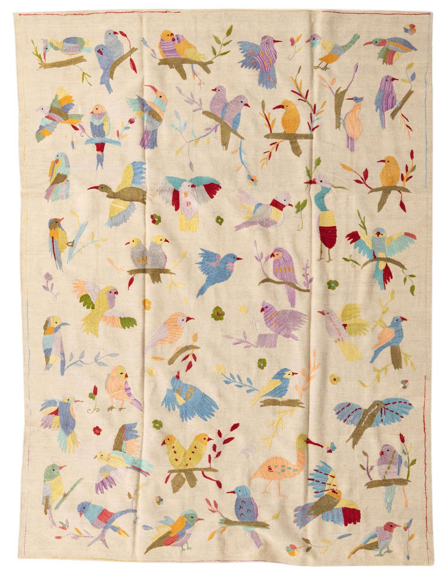 A 7x10 rectangular ivory flatweave rug featuring a vibrant, multicolored bird and floral tribal pattern.