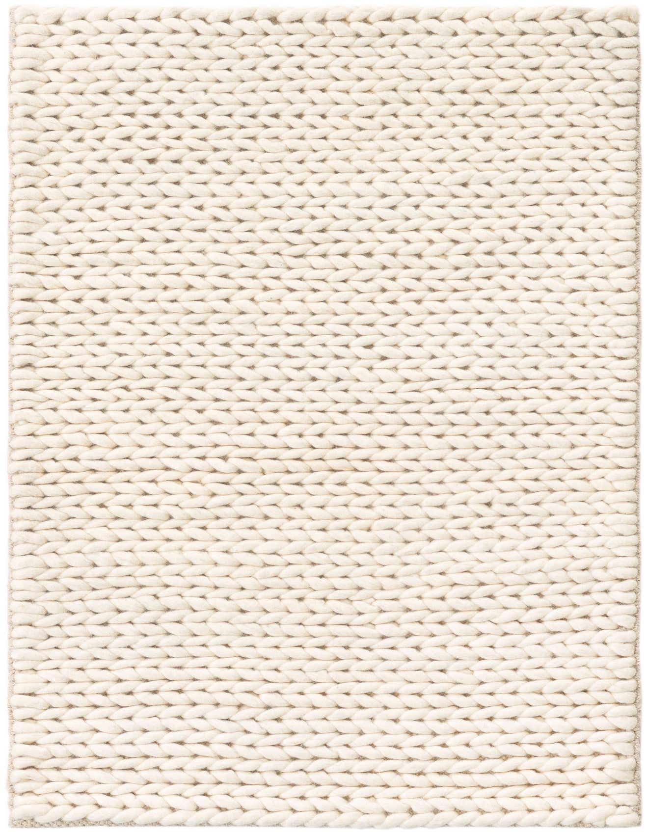 A close-up of a 2x3 rectangular ivory New Zealand wool rug with a thick, textured, braided knit pattern.