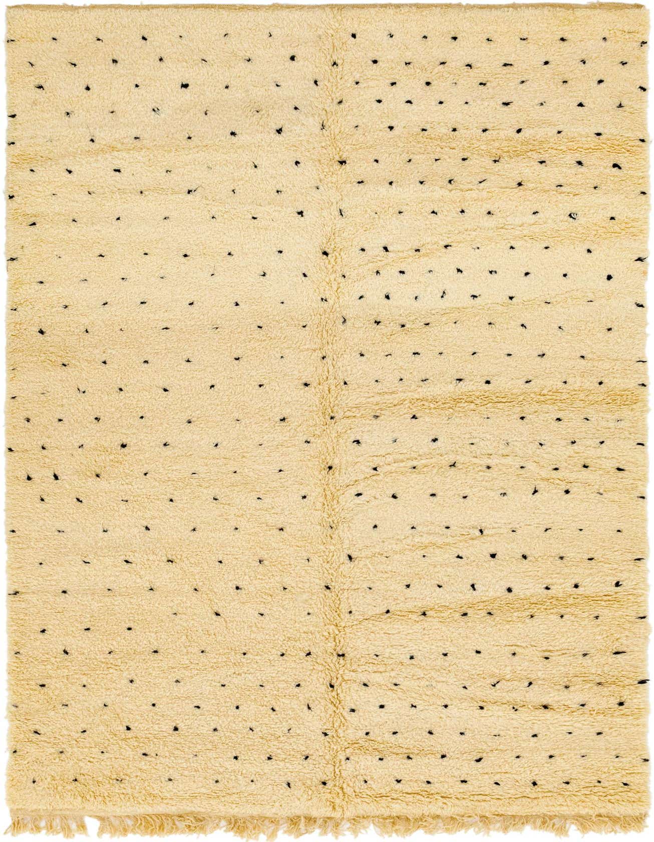 A 6x9 rectangular ivory shag rug with small, irregular black tribal dots, perfect for a living room.