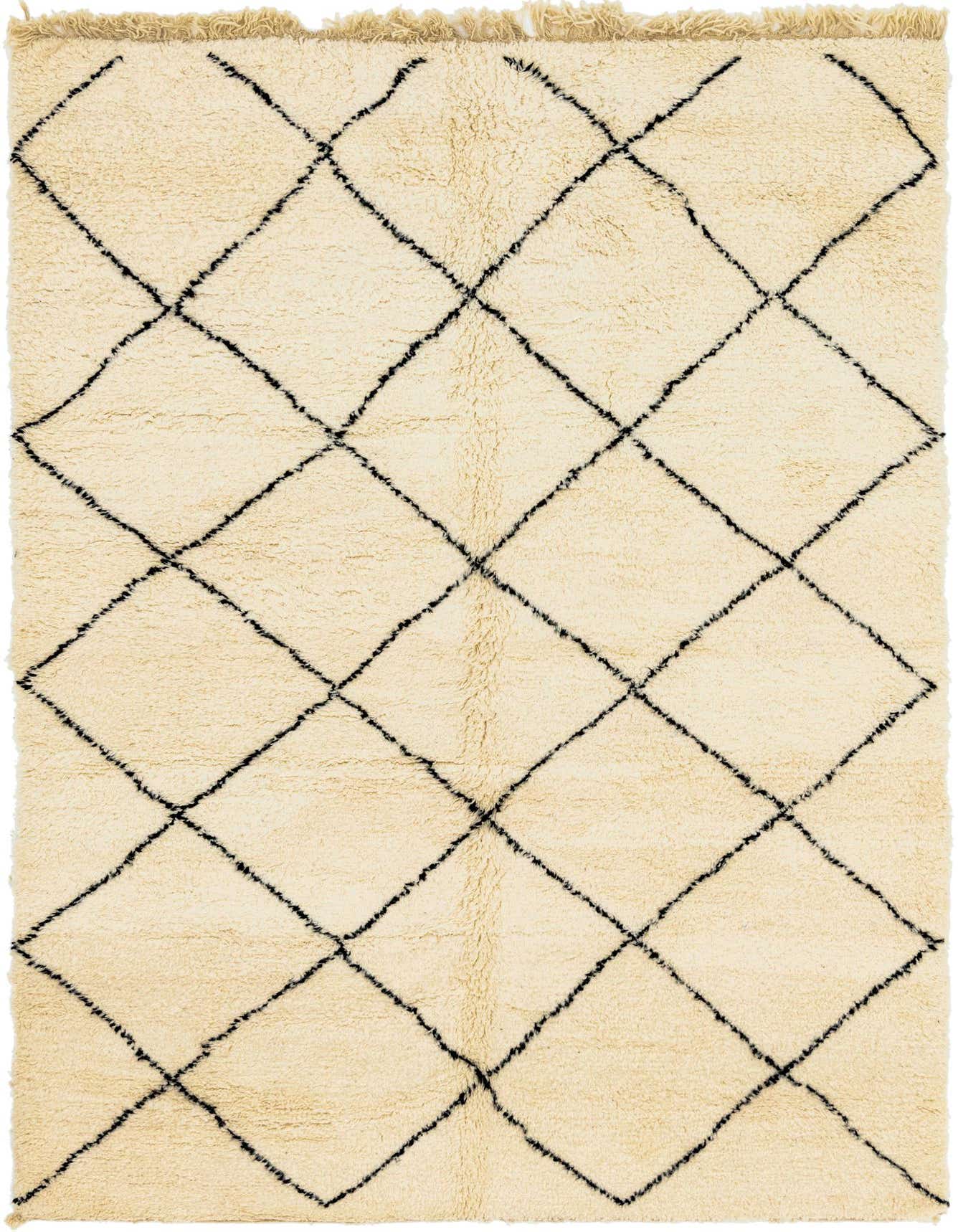 A 7x10 rectangular ivory shag rug with a black tribal diamond pattern and fringed edges, suitable for a living room.