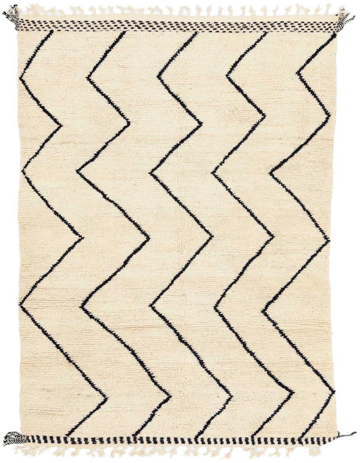 A 6x9 rectangular ivory shag rug with bold black zigzag tribal patterns and fringed edges.