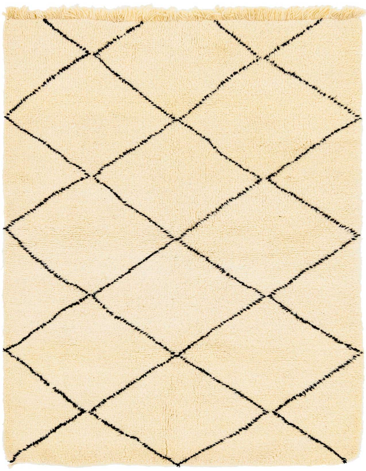 A rectangular 5x8 ivory shag rug with a black tribal diamond pattern and fringed edges, perfect for a modern living room.
