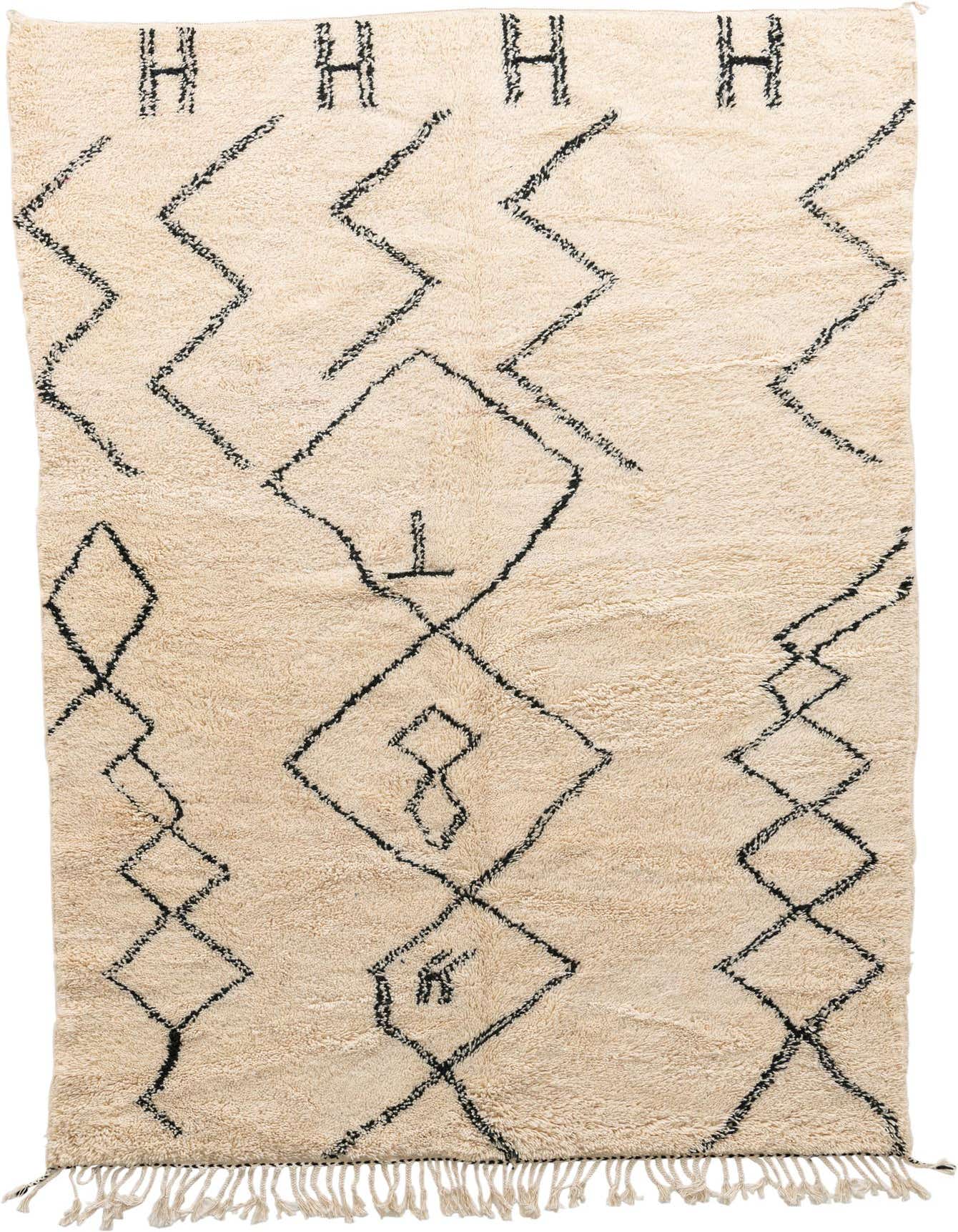 A rectangular 6x9 ivory shag rug with a black tribal geometric pattern and fringe, suitable for a living room.