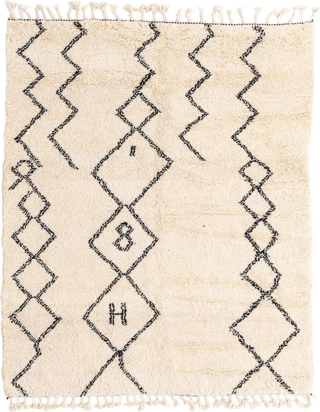 A 5x8 rectangular ivory shag rug with a black tribal geometric diamond pattern and fringe tassels.