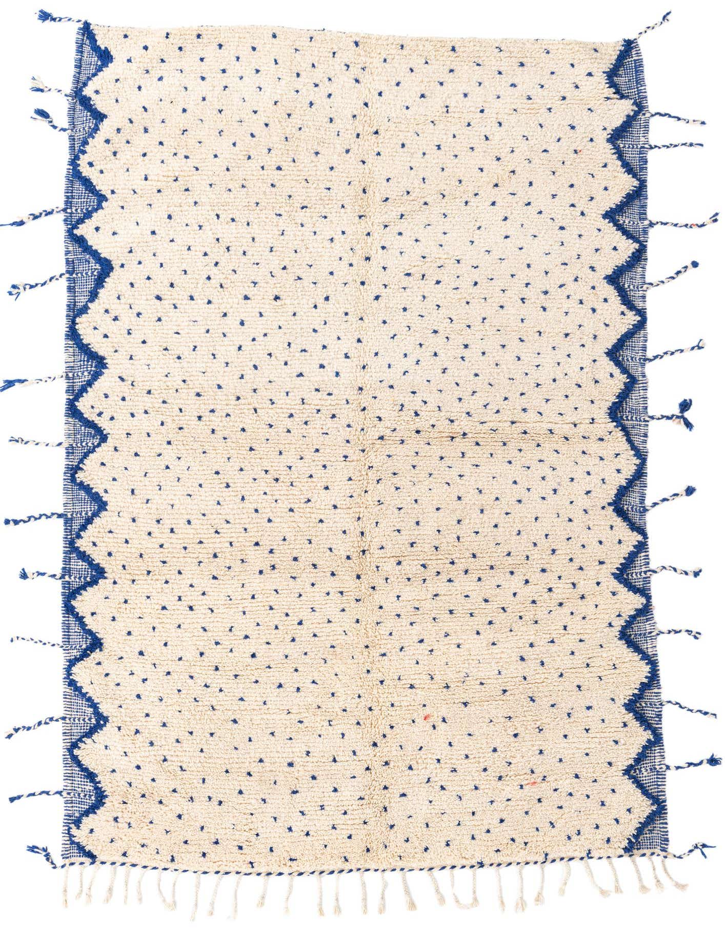 A 5x8 rectangular ivory shag rug with scattered blue tribal dots and a zigzag blue border with tassels.