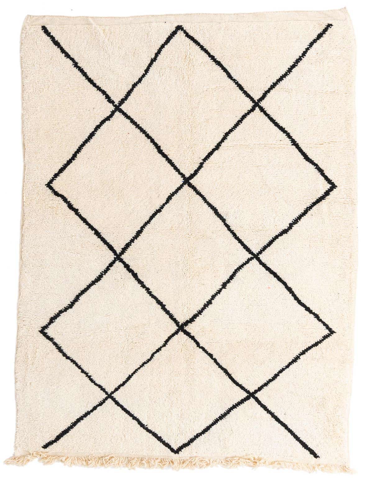 A 6x9 rectangular ivory shag rug with a black tribal diamond pattern and fringed ends, suitable for a living room.