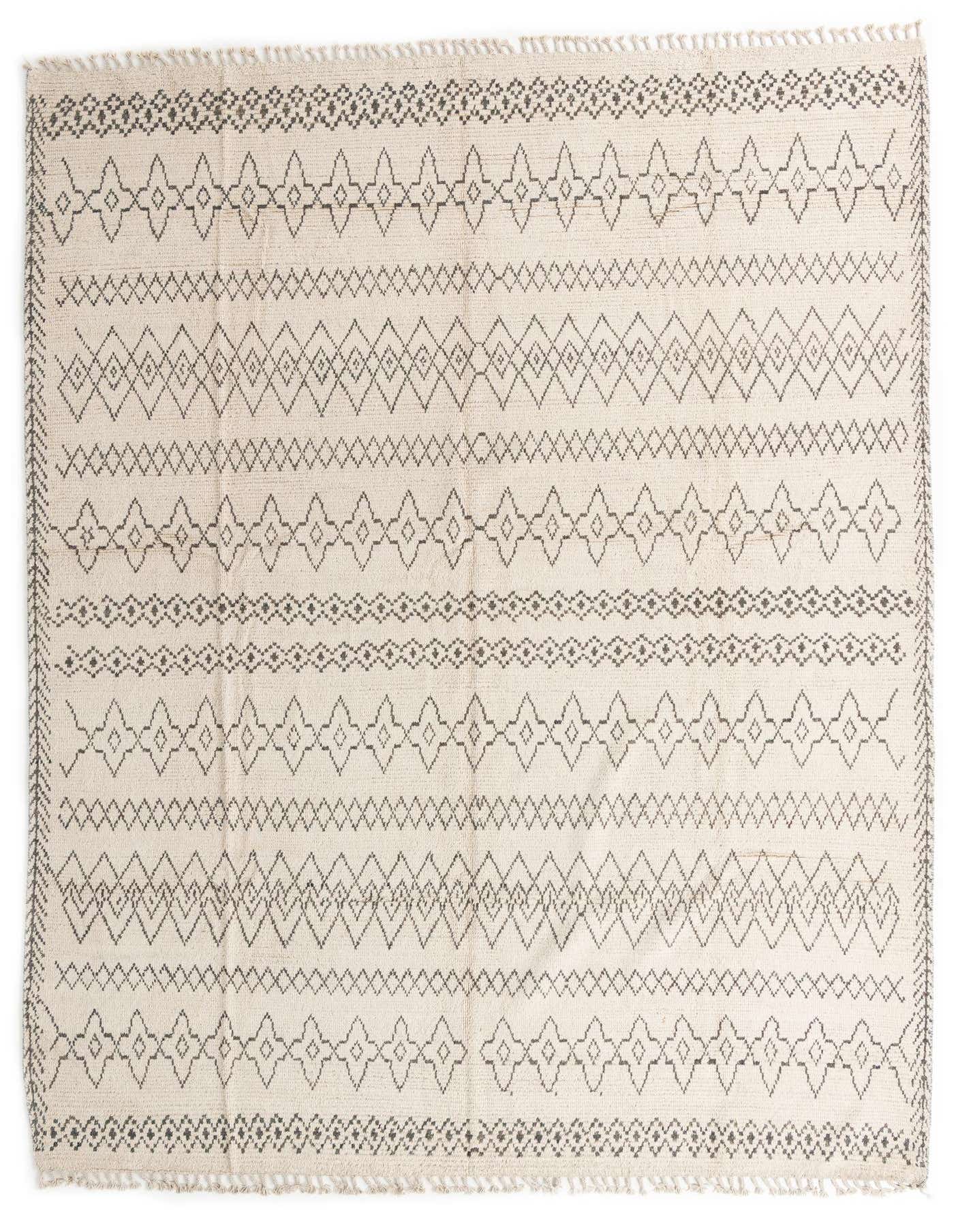 A 10x14 rectangular ivory wool shag rug with a modern tribal pattern in charcoal gray, featuring geometric diamonds and zigzags.