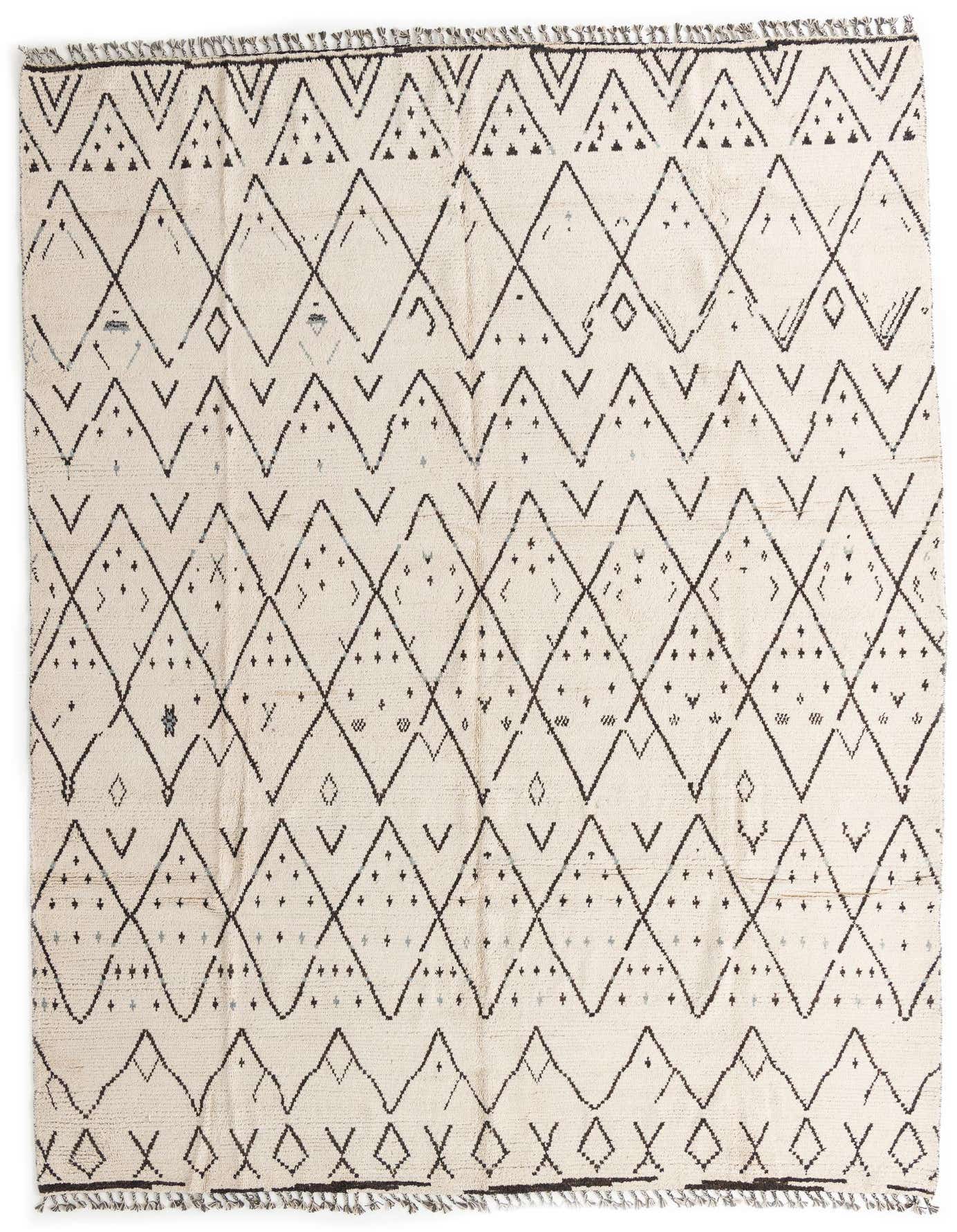 A 10x14 rectangular ivory wool shag rug with a black tribal geometric diamond and chevron pattern.