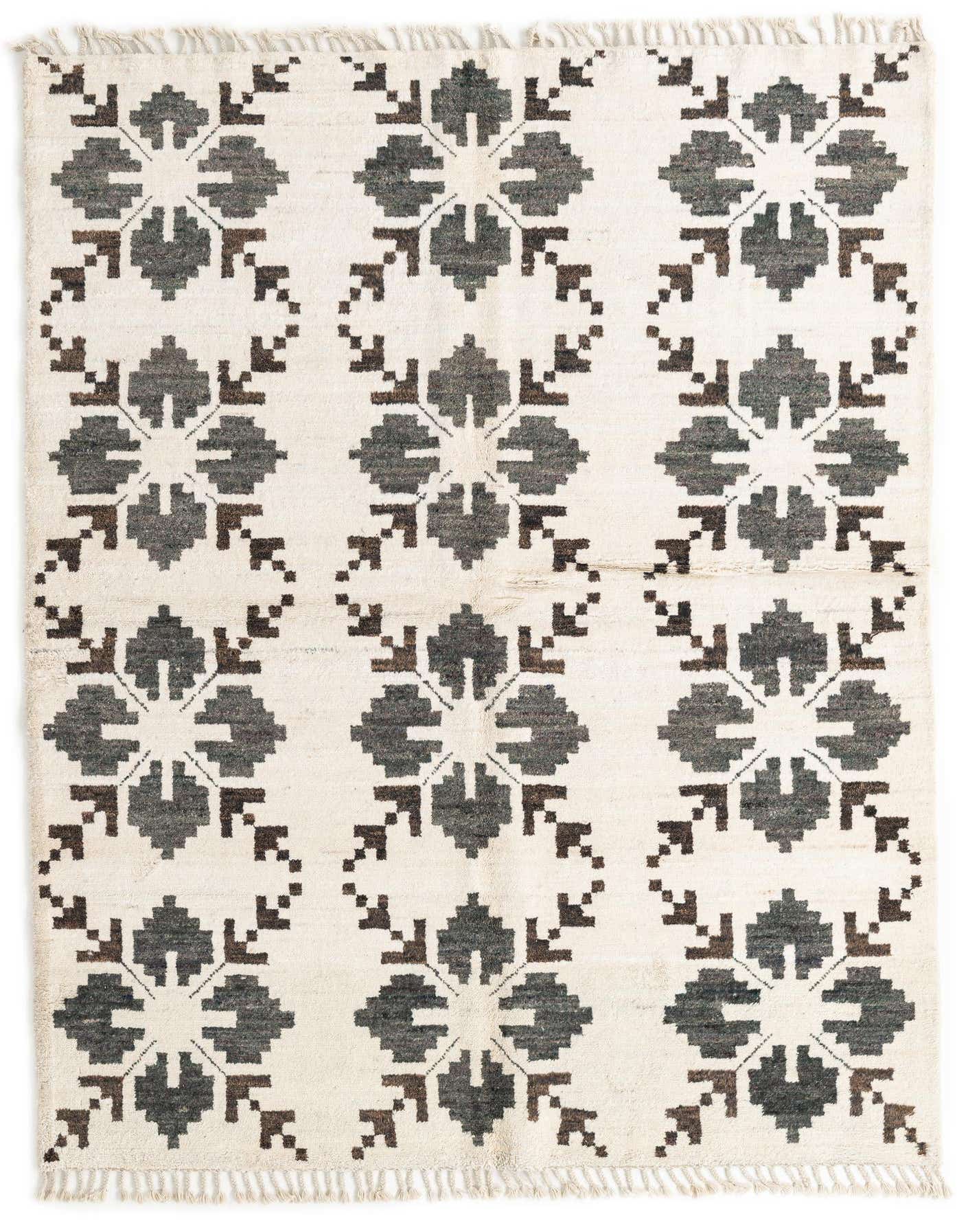 A 5x8 rectangular ivory wool shag rug with a repeating tribal floral pattern in dark gray and brown, featuring fringe.