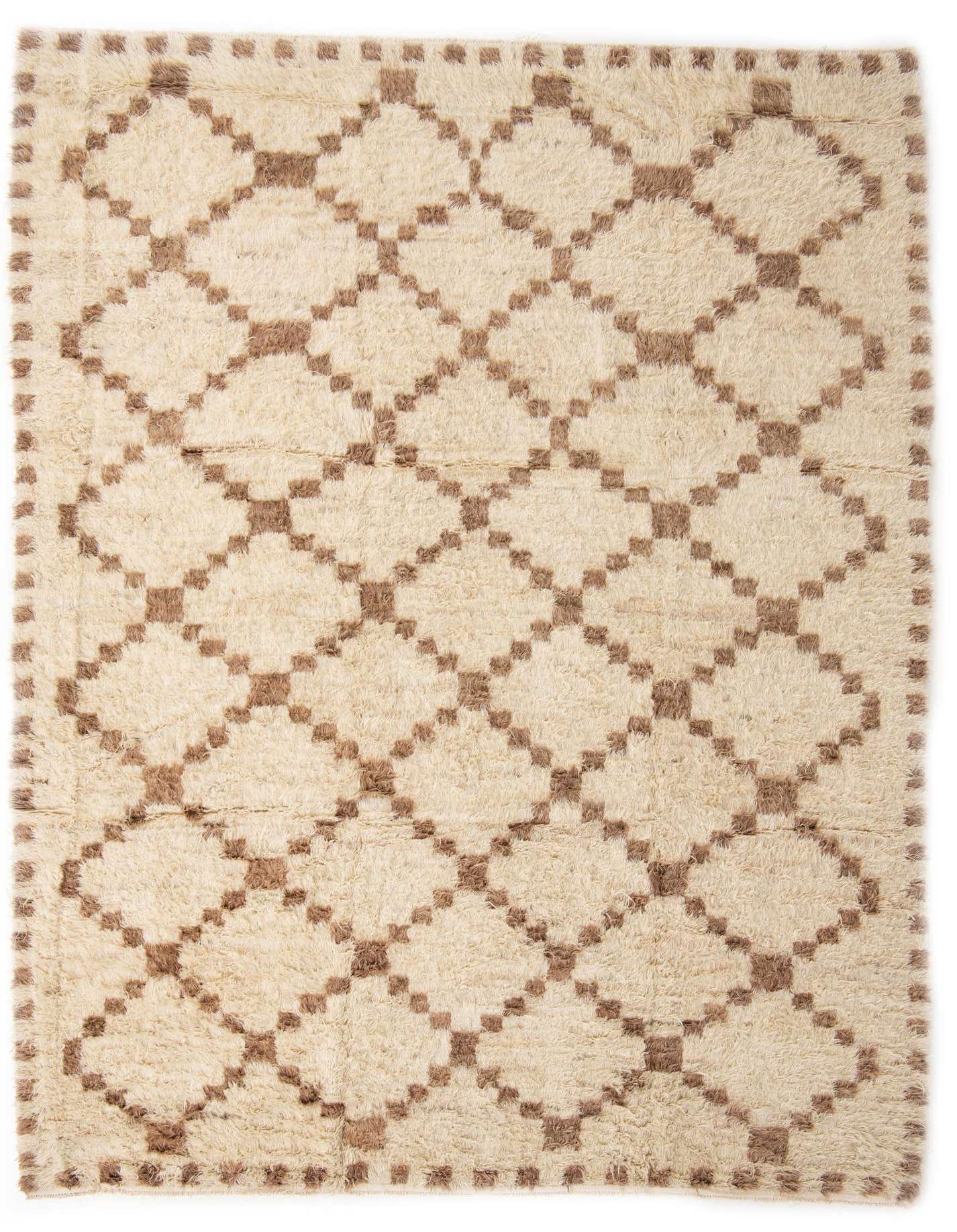 A 10x13 rectangular ivory shag rug with a brown tribal geometric pattern, suitable for a living room.