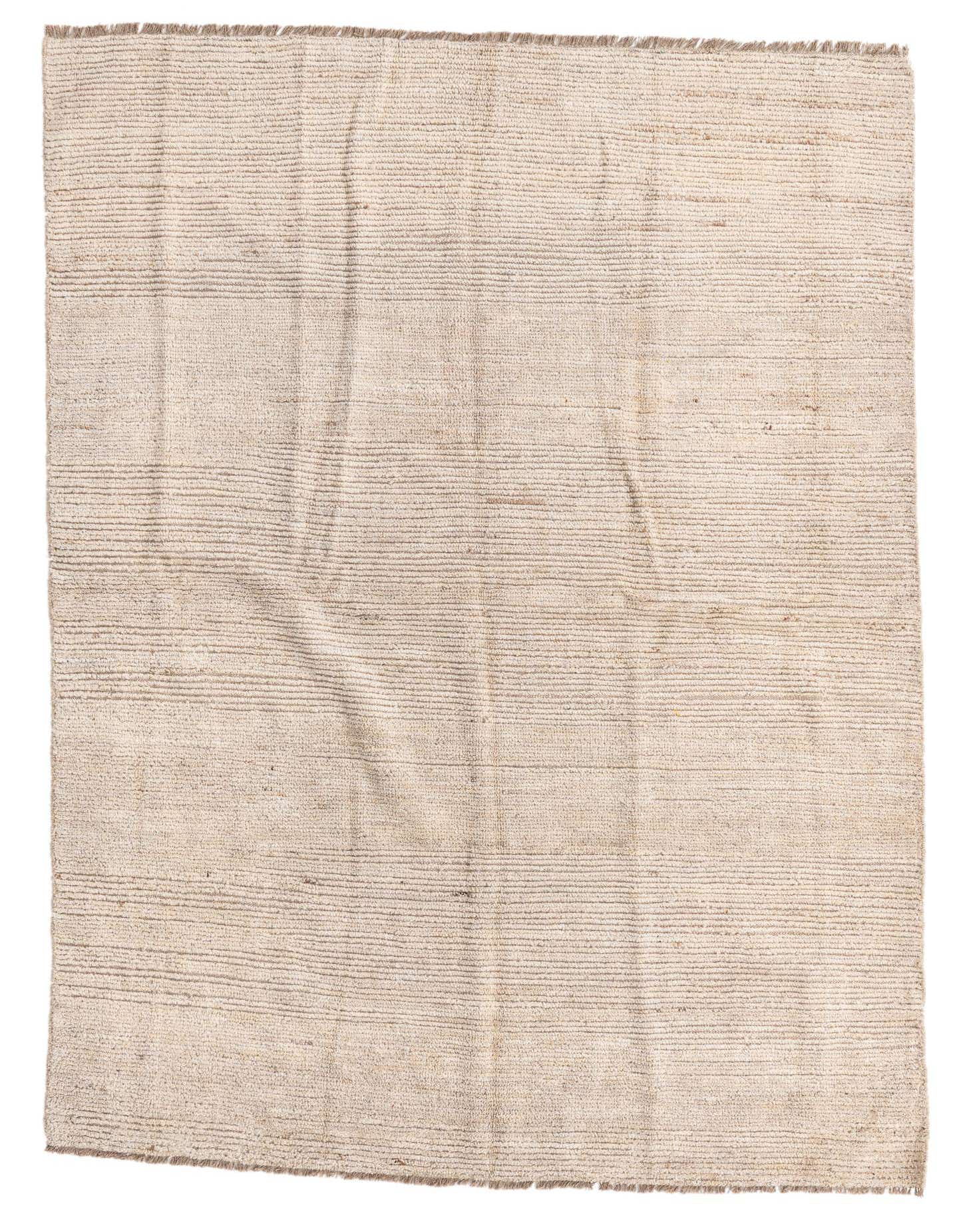 A 6x9 rectangular ivory shag rug with subtle horizontal tribal patterns, handmade from wool.