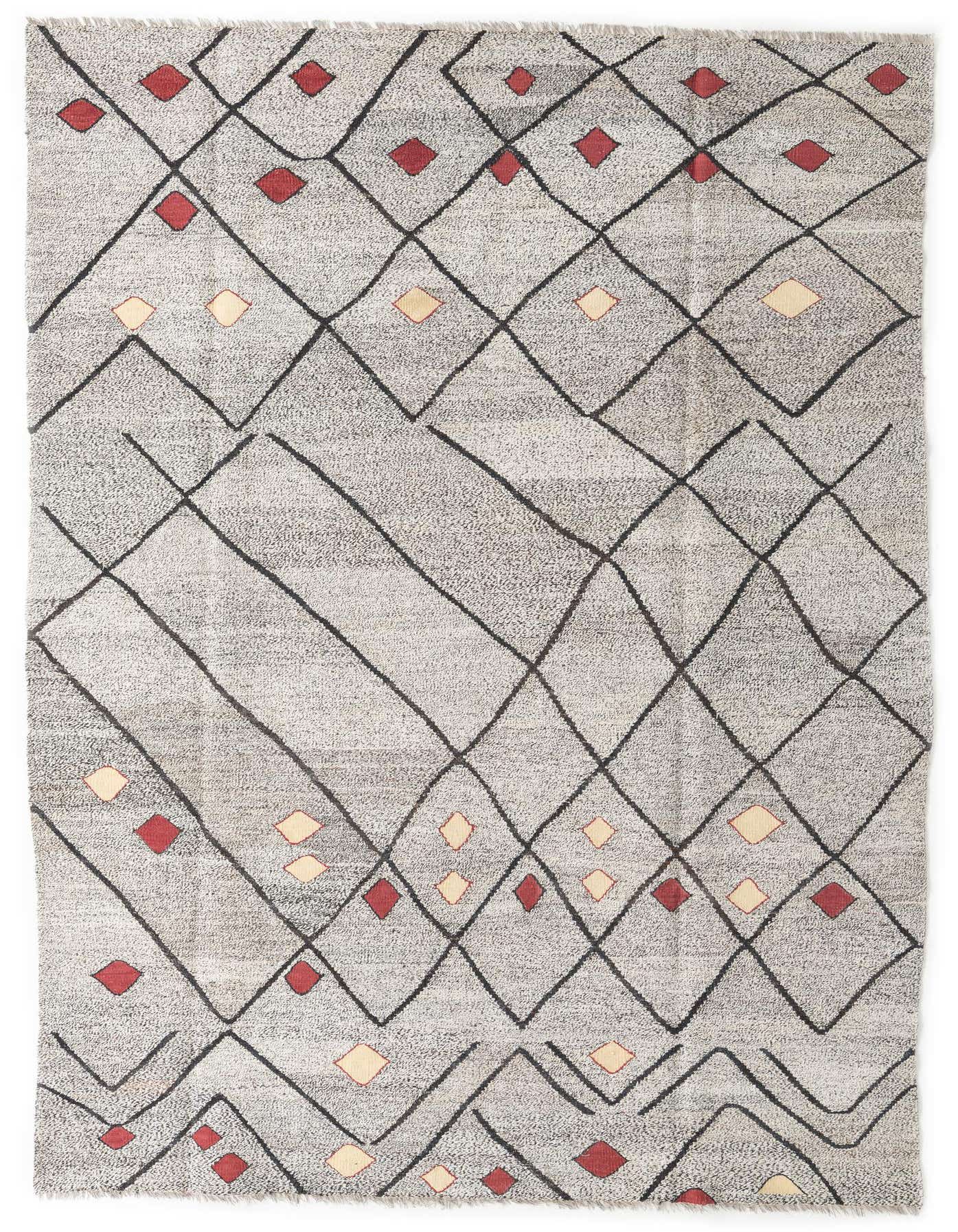 A 7x10 rectangular ivory shag rug with a modern tribal pattern of black intersecting lines and scattered red and cream diamond shapes.