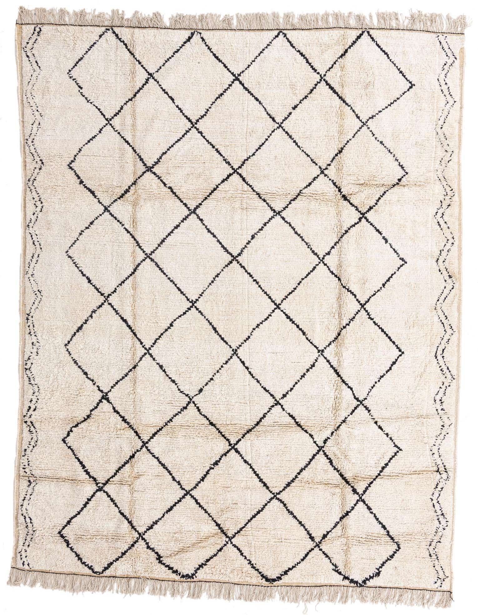 An 8x10 rectangular ivory shag rug with a black tribal diamond pattern and fringed edges, perfect for a modern living room.