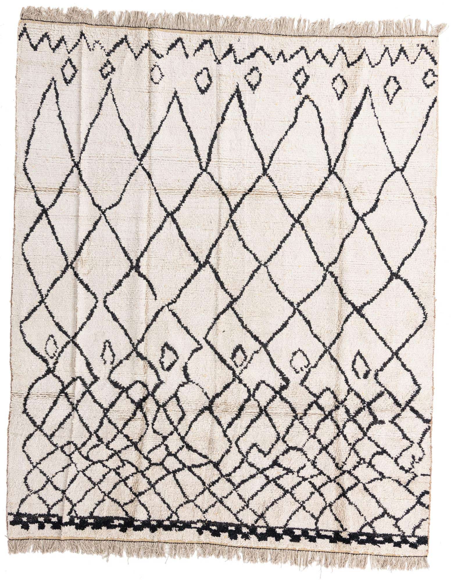 An 8x10 rectangular ivory shag rug with a bold black tribal diamond pattern and fringe.