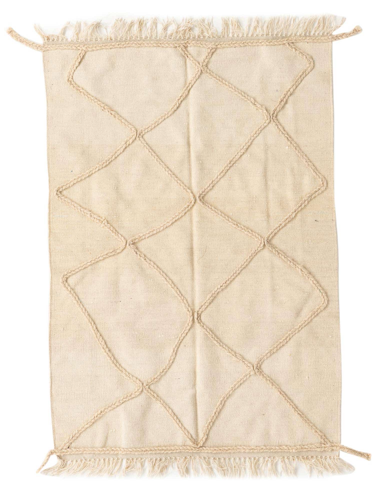 A 3x5 rectangular ivory wool shag rug featuring a raised diamond tribal pattern and fringed edges, suitable for indoor use.