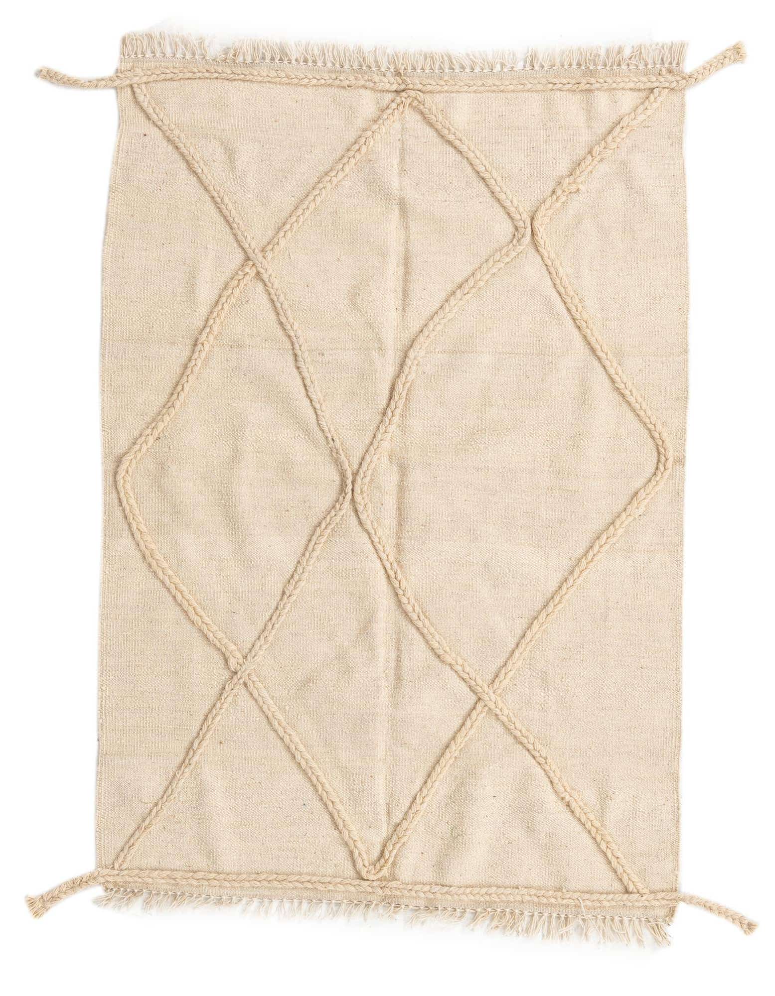 A 4x6 rectangular ivory wool shag rug with a braided diamond tribal pattern and fringed edges.