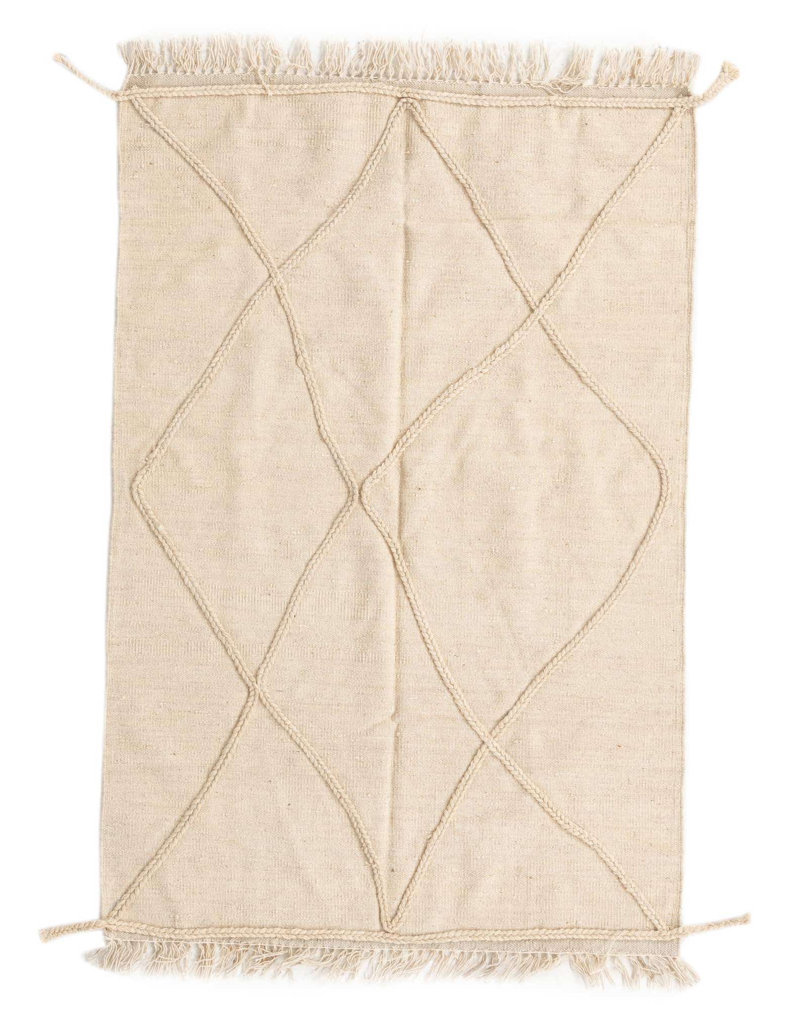 A 3x5 rectangular ivory wool shag rug with a braided diamond tribal pattern and fringe.