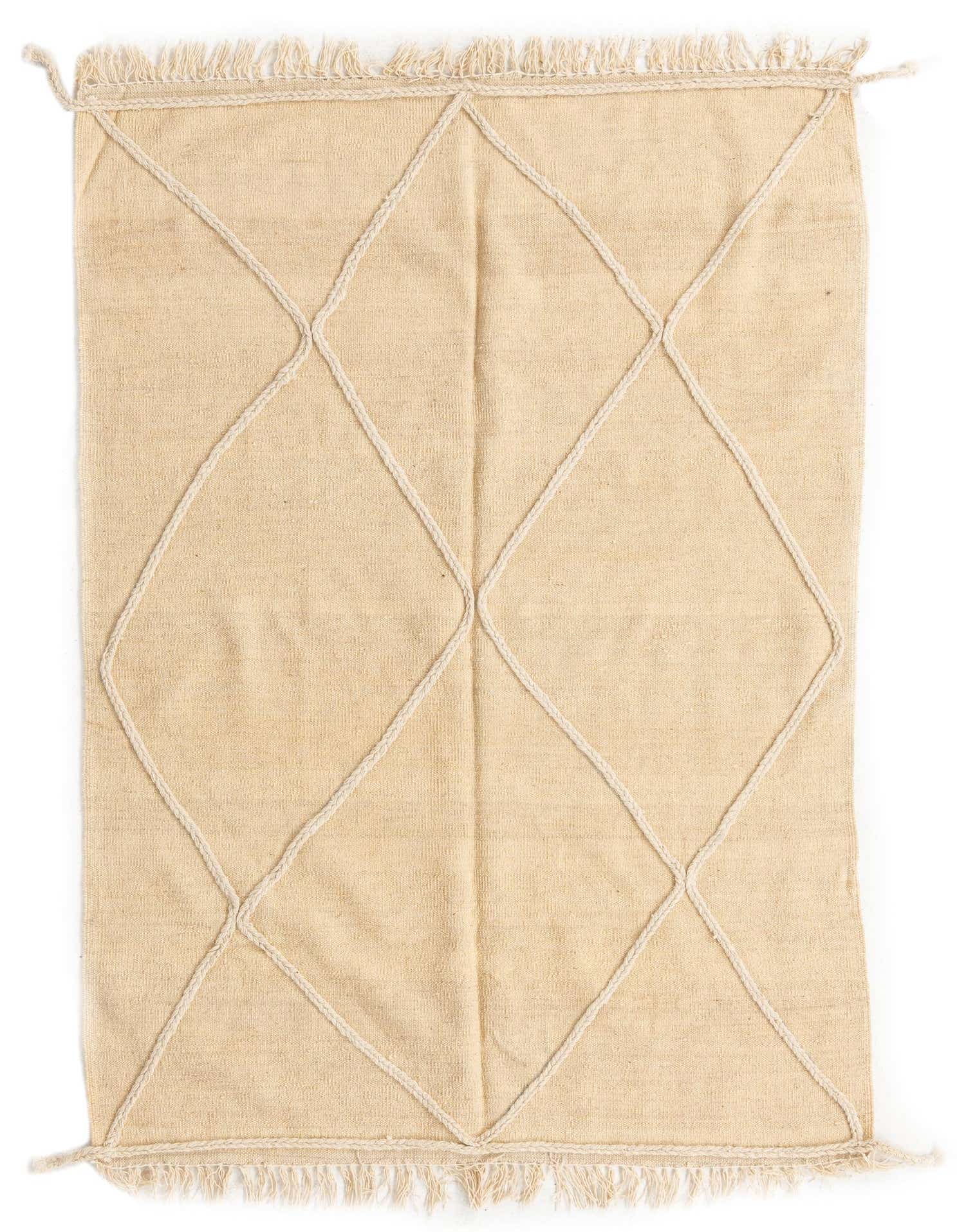 A 4x6 rectangular ivory wool shag rug with a white tribal diamond pattern and fringe ends, suitable for a living room.
