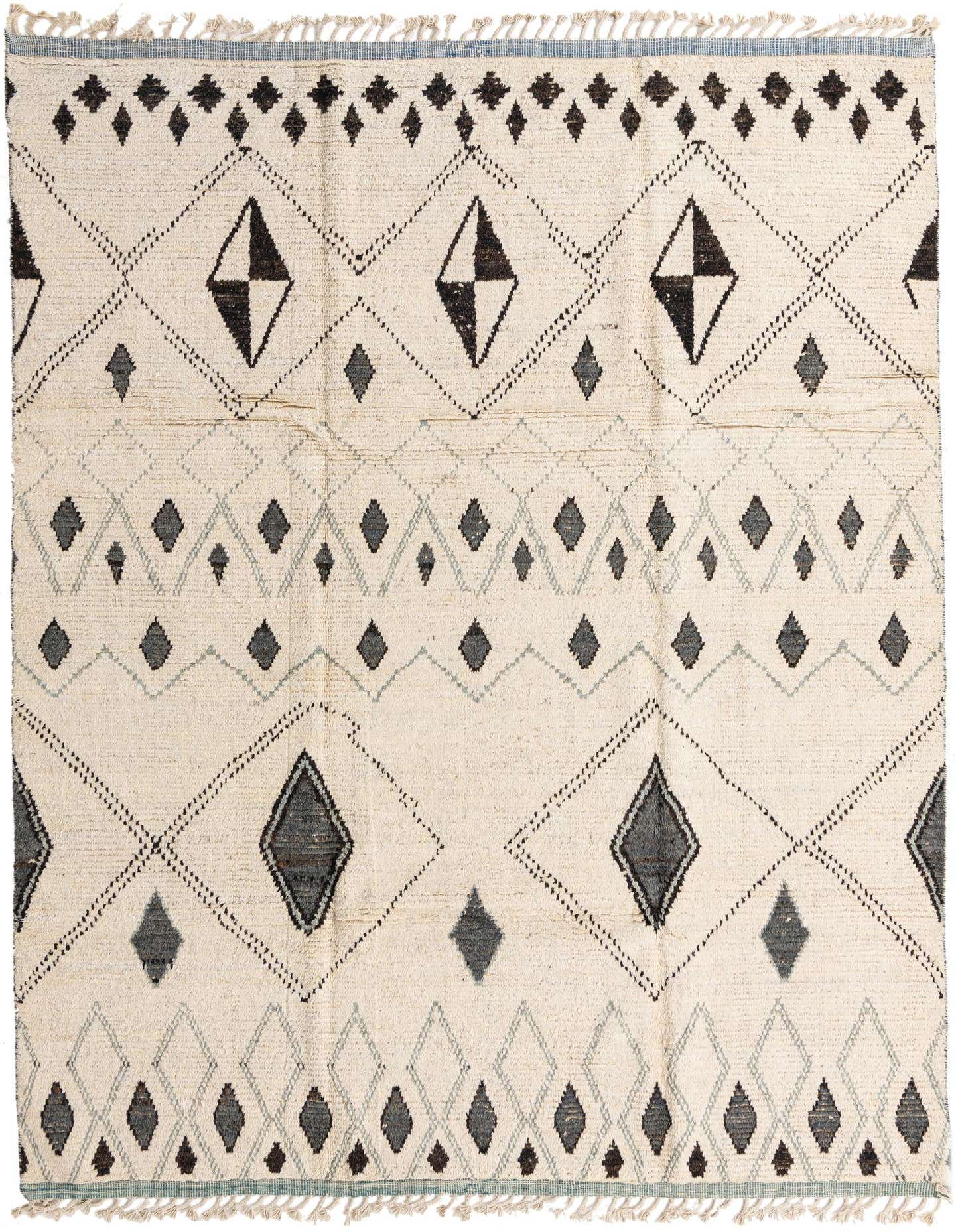 An 8x11 rectangular ivory wool shag rug with a modern tribal pattern of black and gray diamonds and geometric lines.