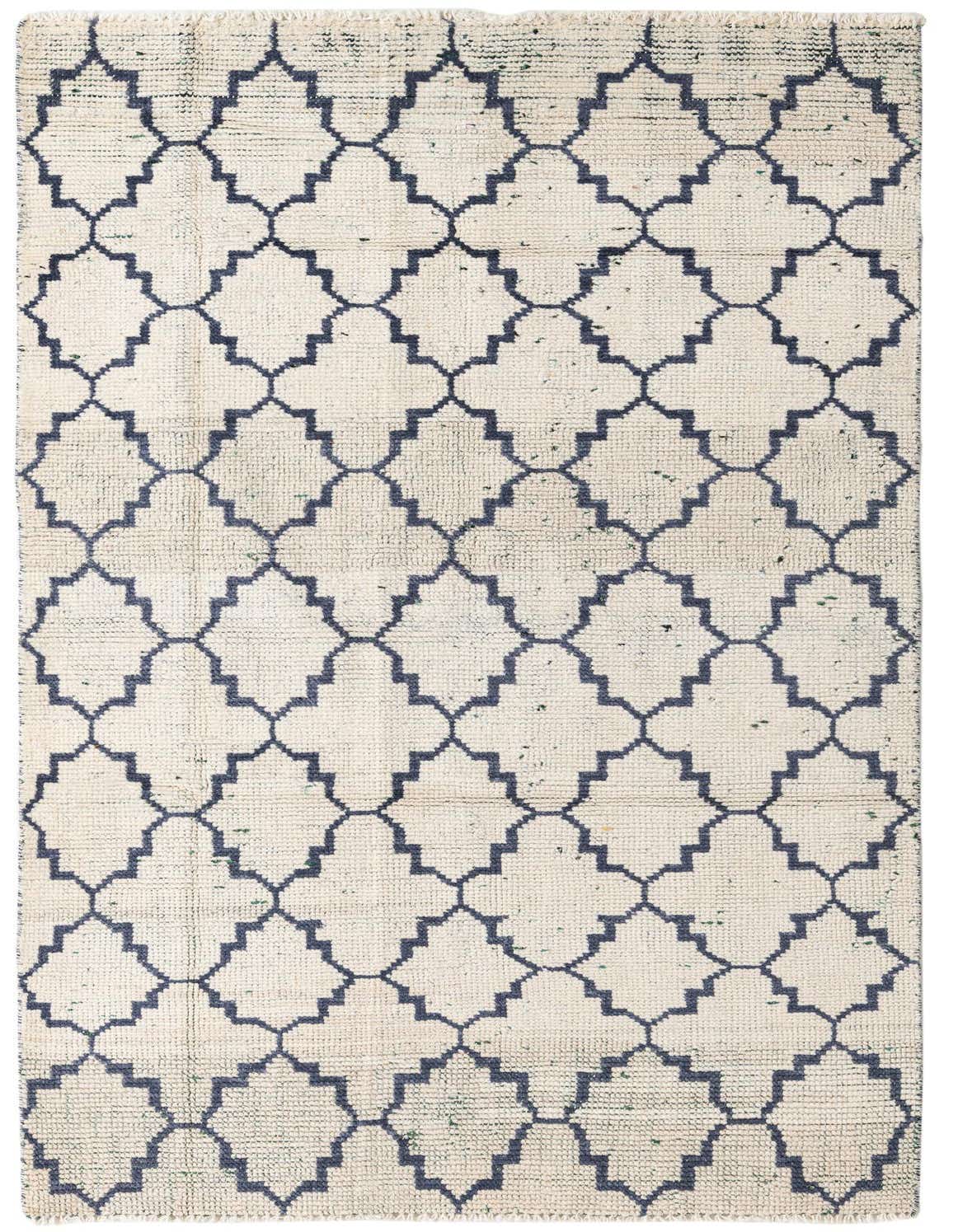 A 5x8 rectangular ivory shag rug with a repeating dark blue tribal geometric pattern, suitable for a living room.