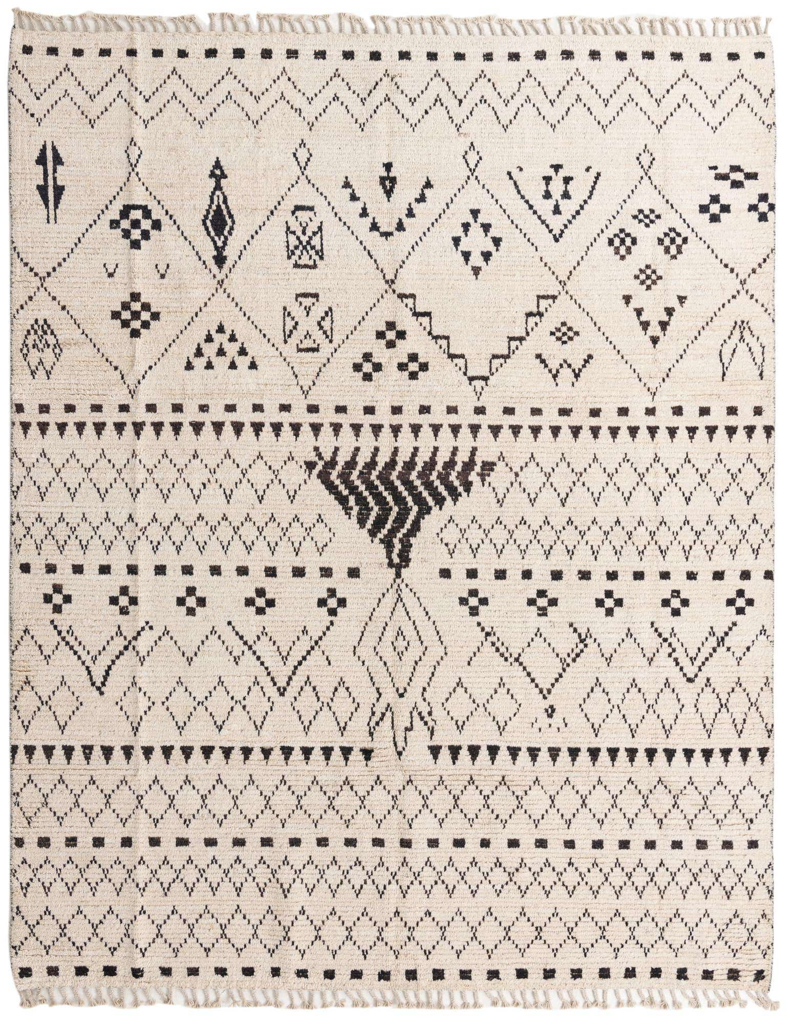 An 8x10 rectangular ivory shag rug with a black tribal and abstract pattern, featuring diamonds, zigzags, and unique symbols.
