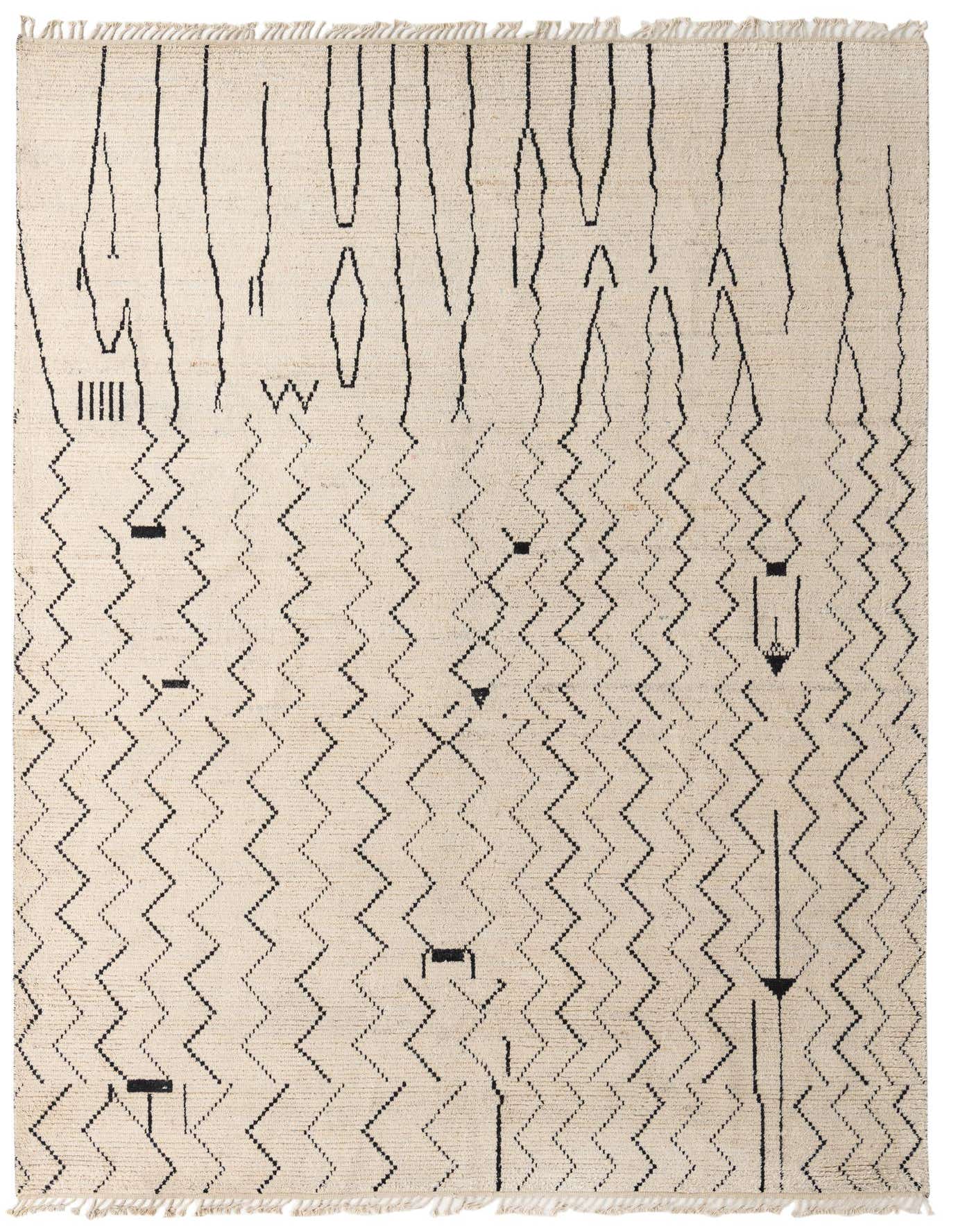 A 10x14 rectangular ivory shag rug with a modern tribal pattern of black zigzags and abstract lines.