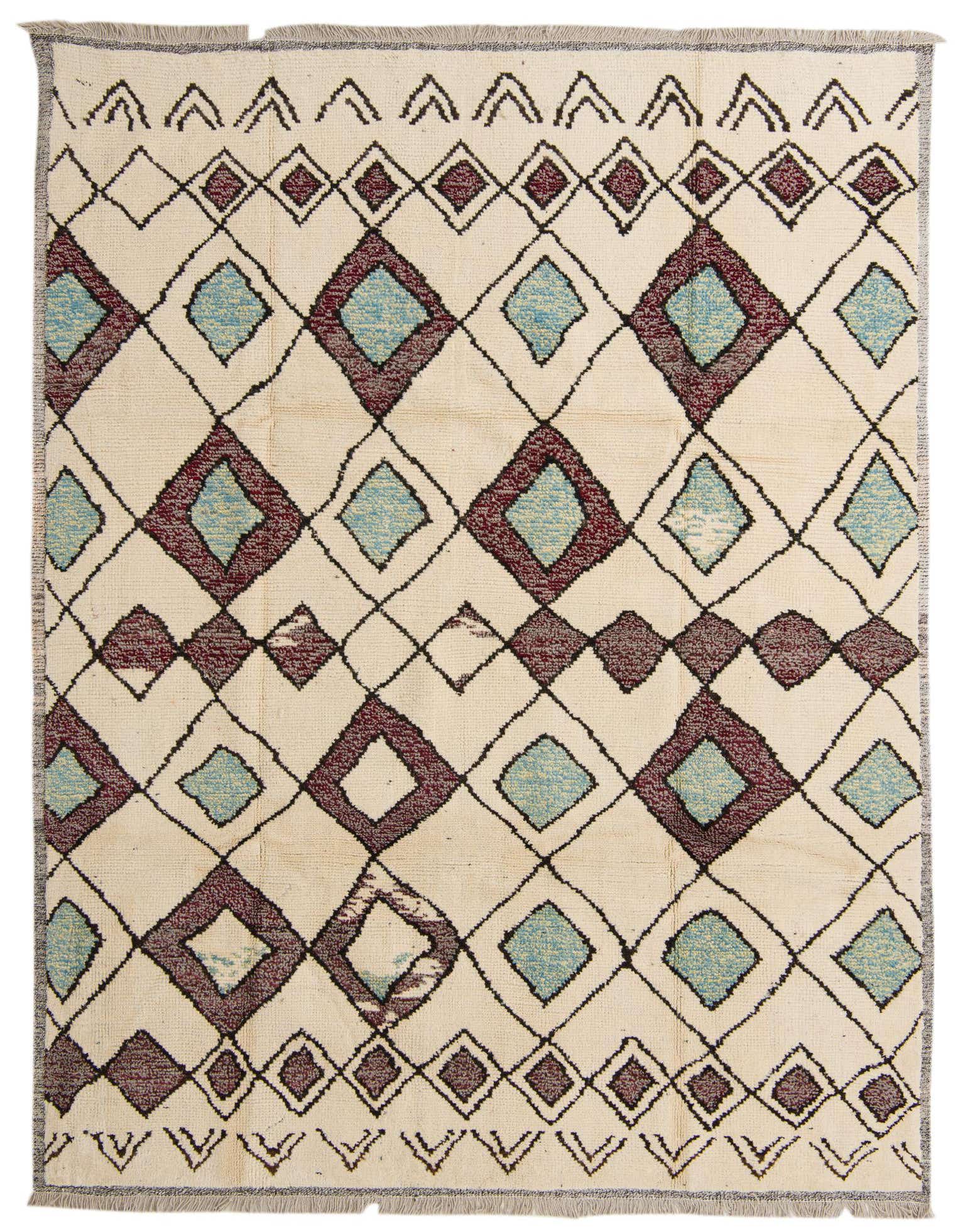 An 8x10 rectangular ivory wool shag rug with a tribal geometric pattern of teal and maroon diamonds.