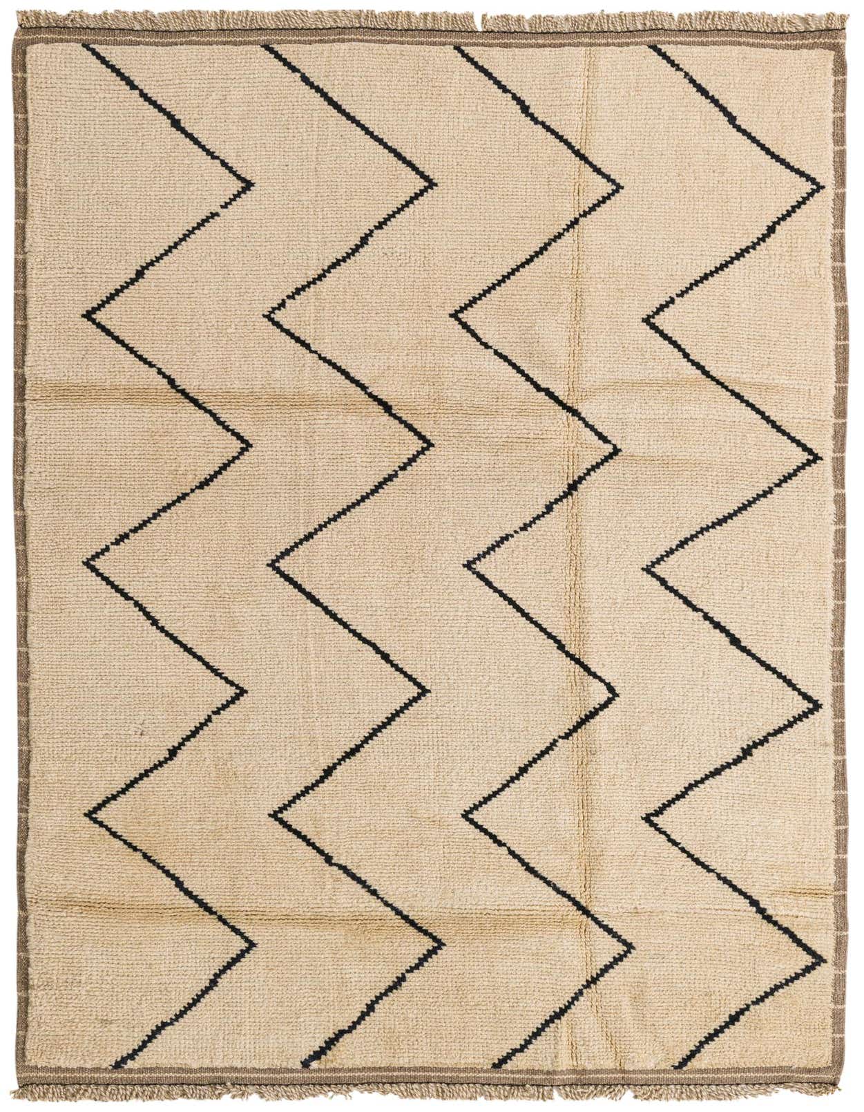 A 5x8 rectangular ivory shag rug with bold black zigzag tribal patterns and fringed edges, perfect for a modern living room.