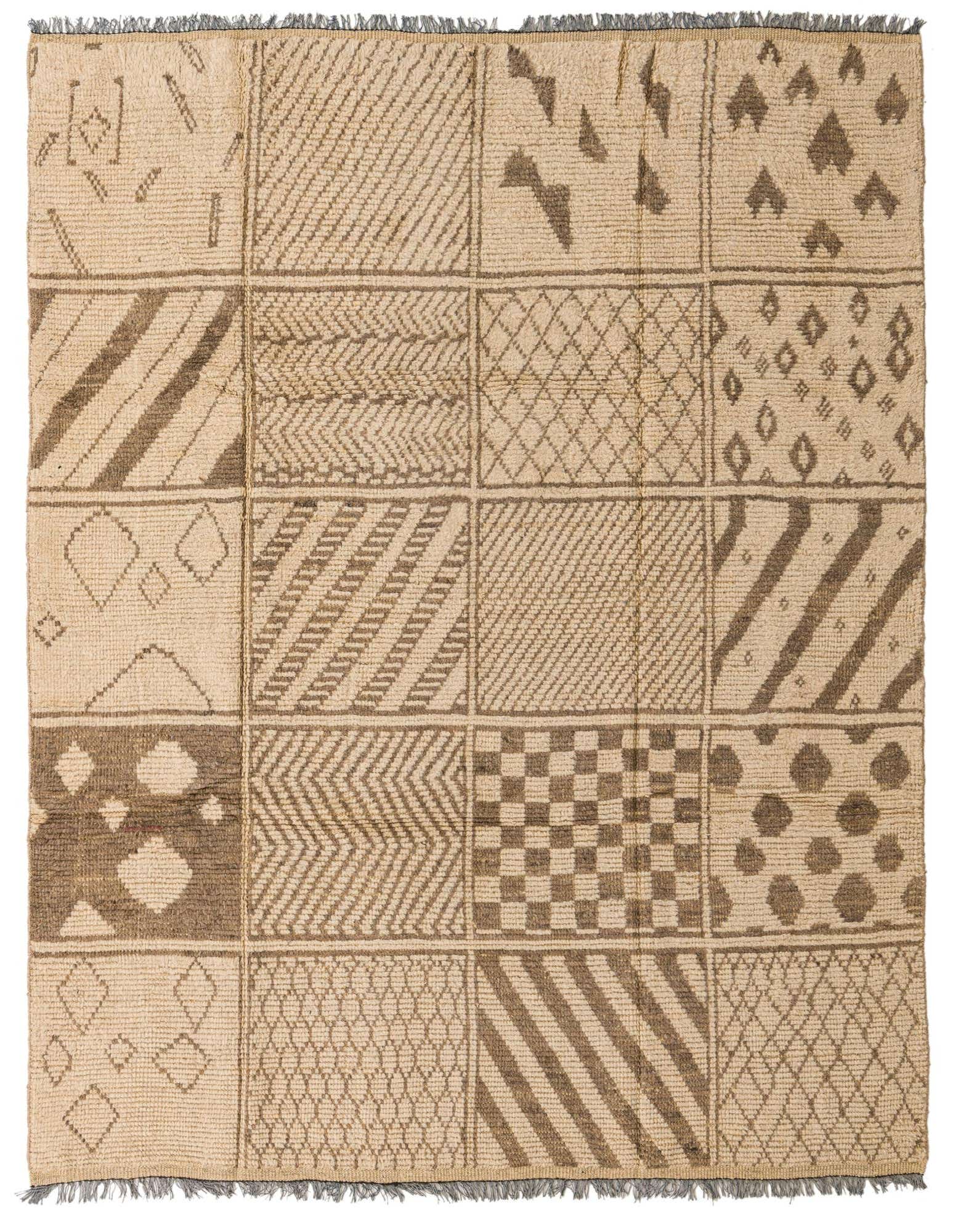 An 8x11 rectangular ivory wool shag rug with a modern tribal patchwork design featuring various geometric patterns.