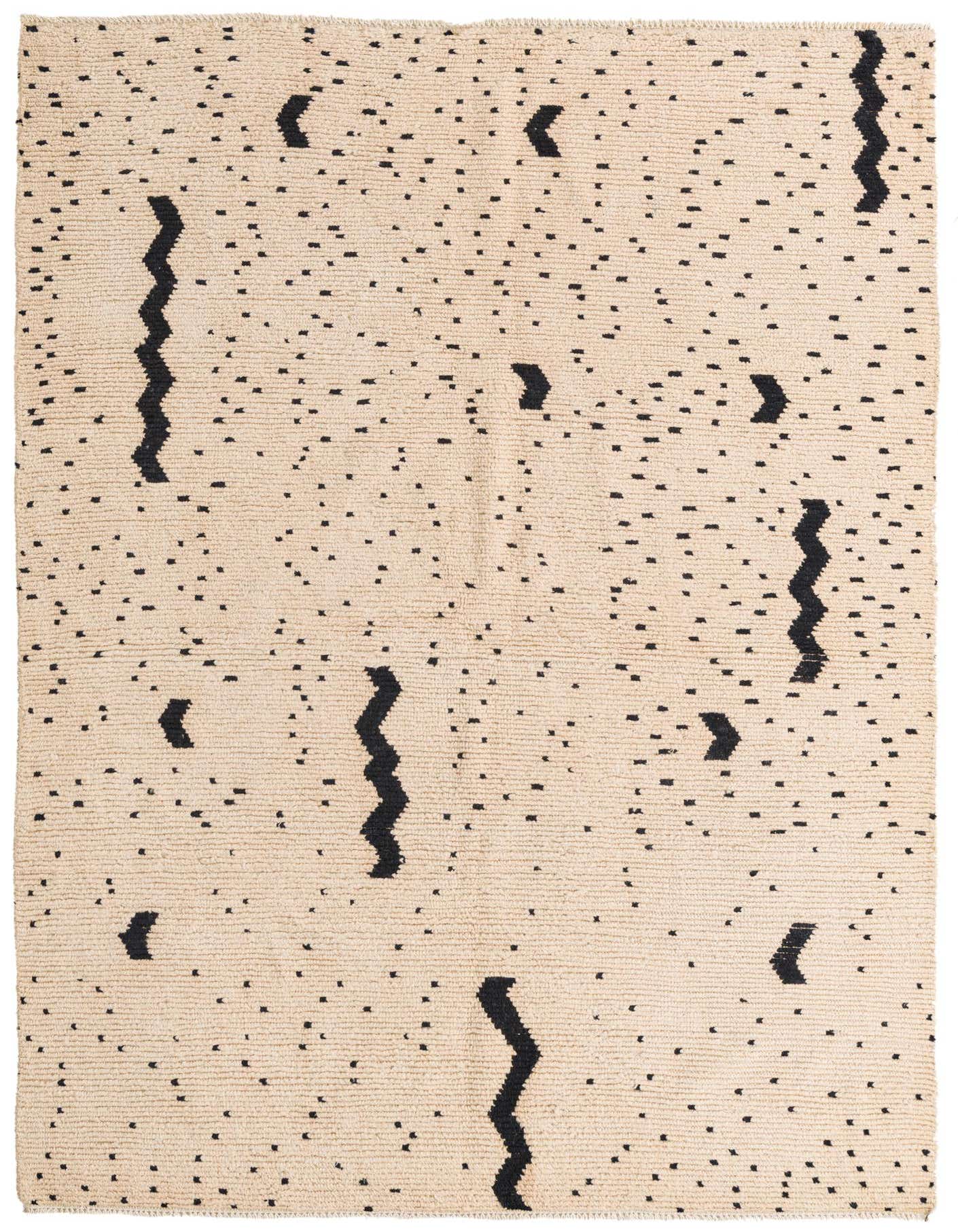 A 5x8 rectangular ivory shag rug with a modern tribal pattern of scattered black dots and abstract wavy lines.