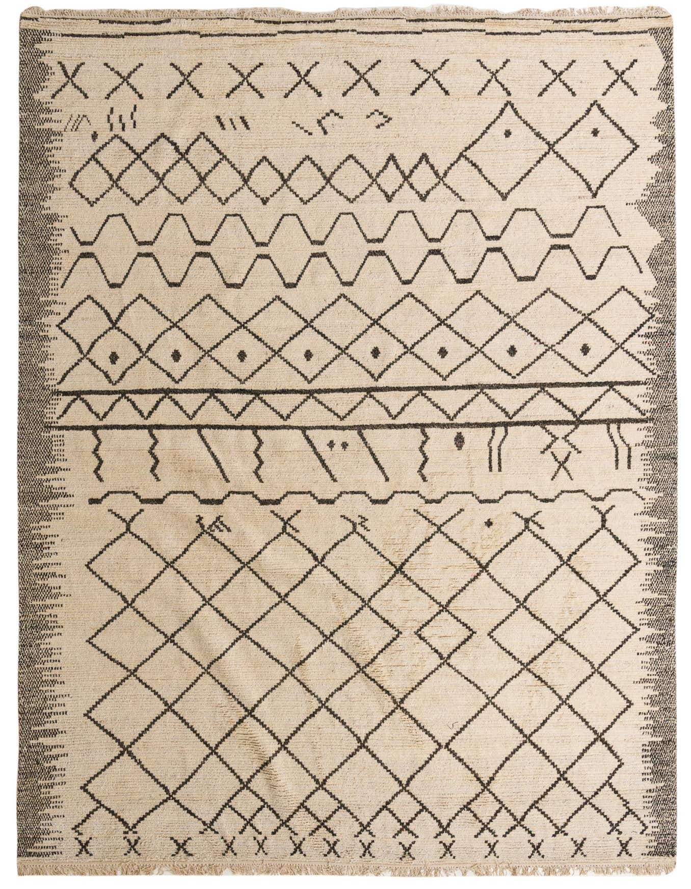 A 10x14 rectangular ivory wool shag rug with a black tribal geometric pattern, perfect for a modern living room.