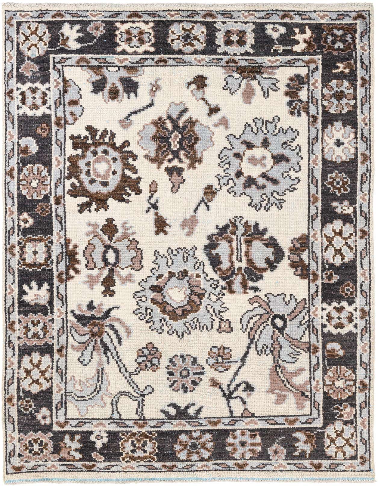A 6x9 rectangular ivory wool shag rug with a tribal floral pattern in brown, gray, and black, perfect for a living room.