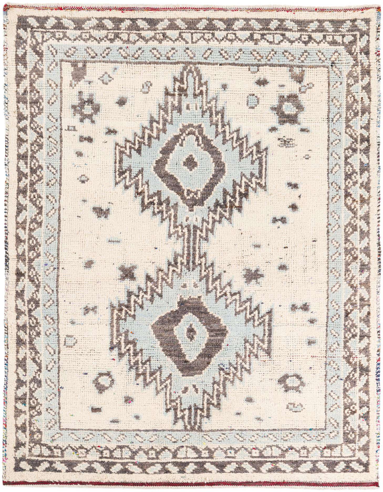 A 5x8 rectangular ivory wool shag rug with a light blue and dark gray tribal geometric pattern.