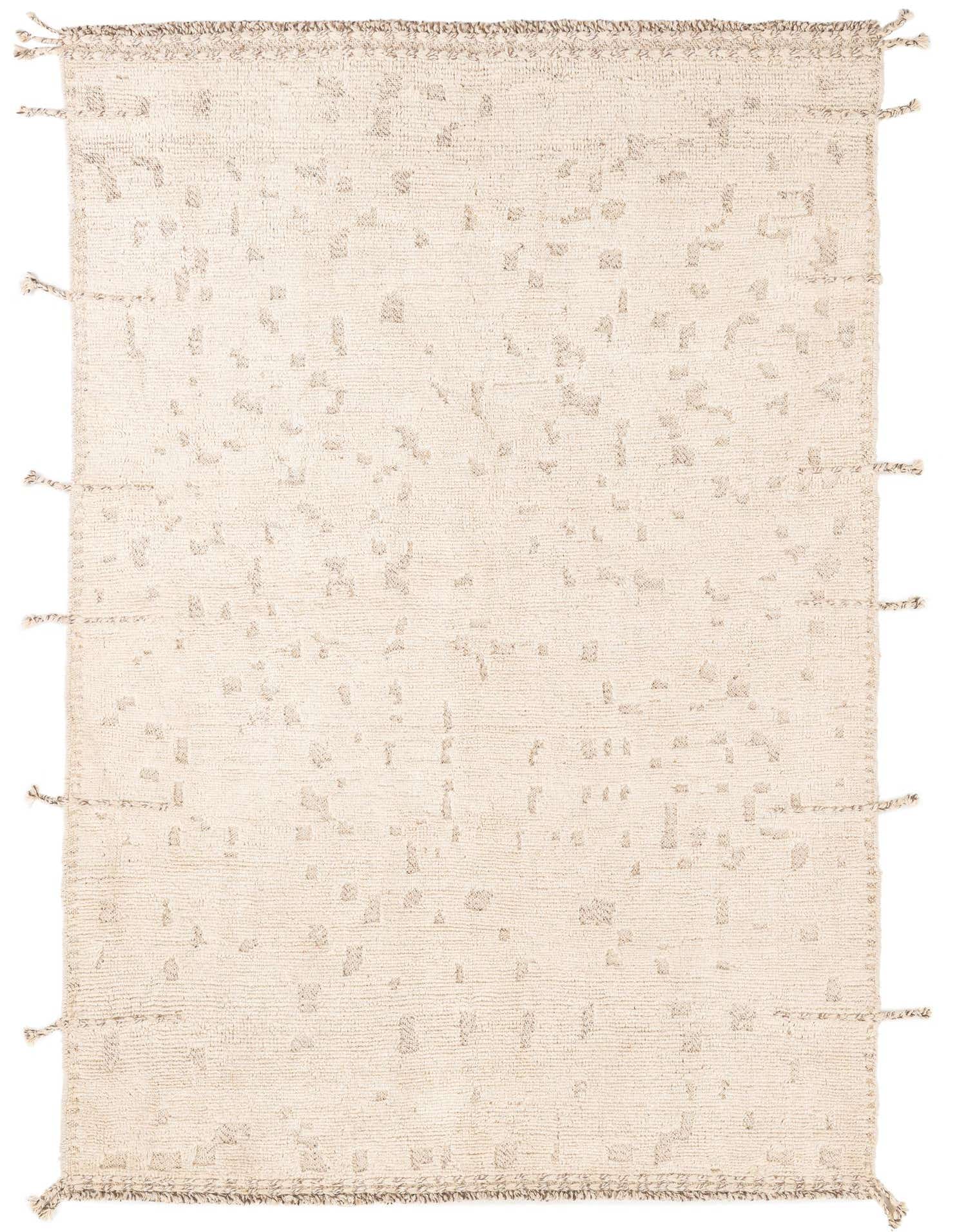 A 5x8 rectangular ivory wool shag rug with subtle abstract tribal patterns and decorative tassels on the edges, suitable for a living room.