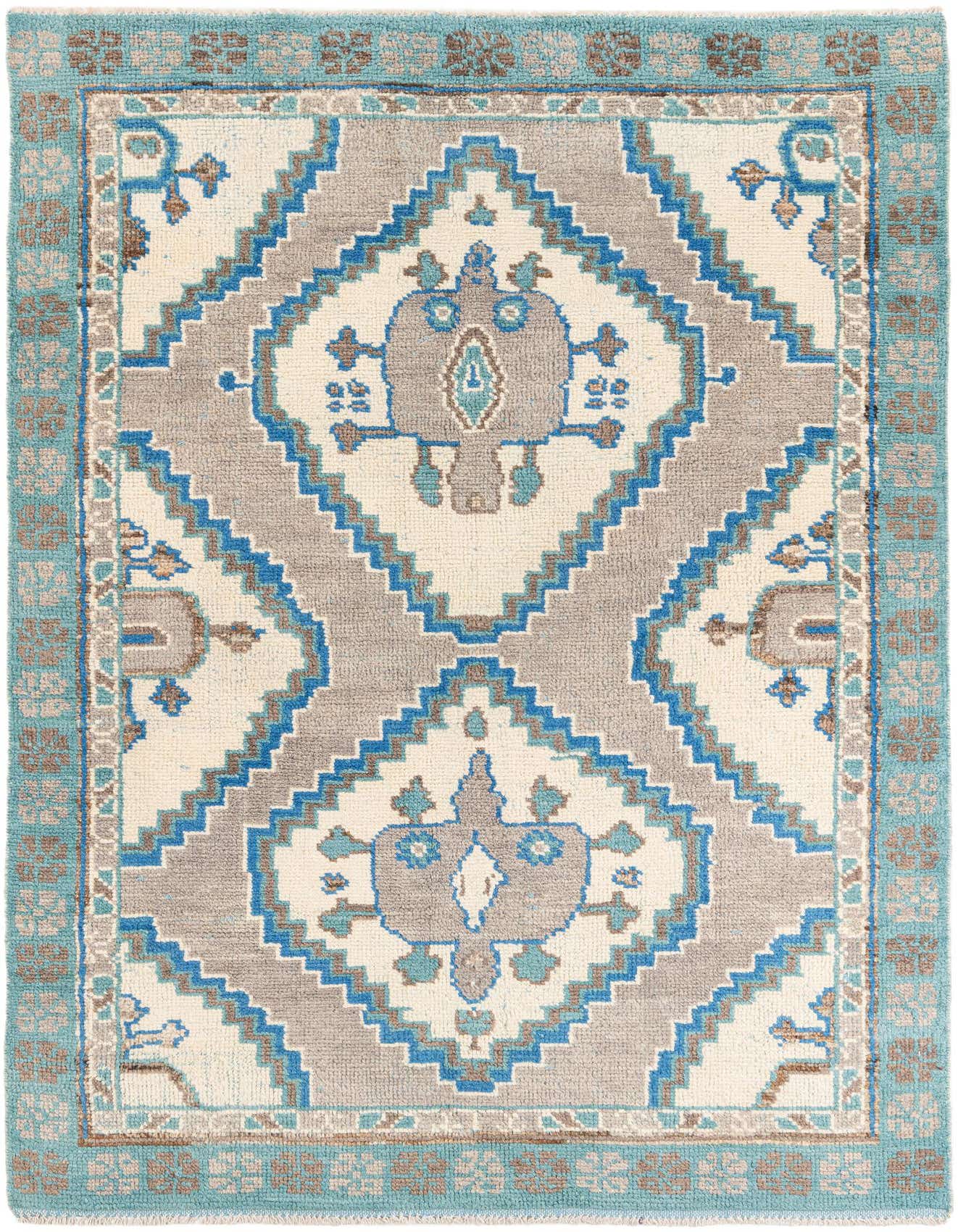A 6x9 rectangular ivory and blue wool shag rug with a tribal medallion pattern, ideal for a living room.