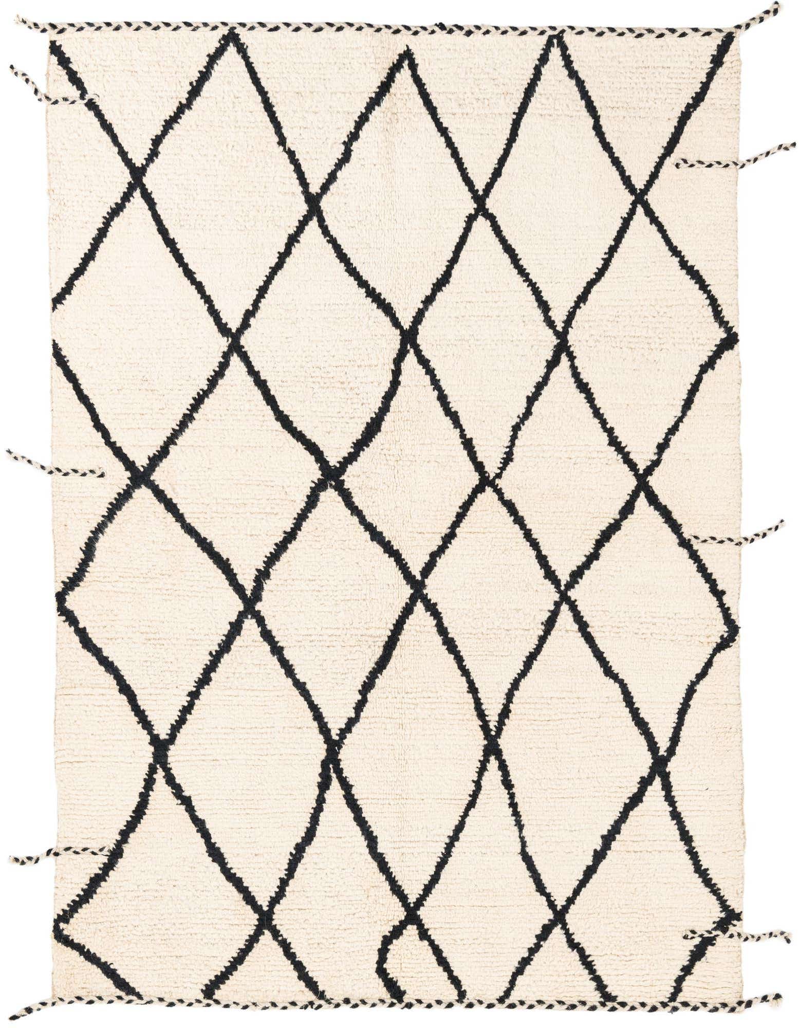A rectangular 5x8 ivory shag rug with a bold black tribal diamond pattern and braided tassels.