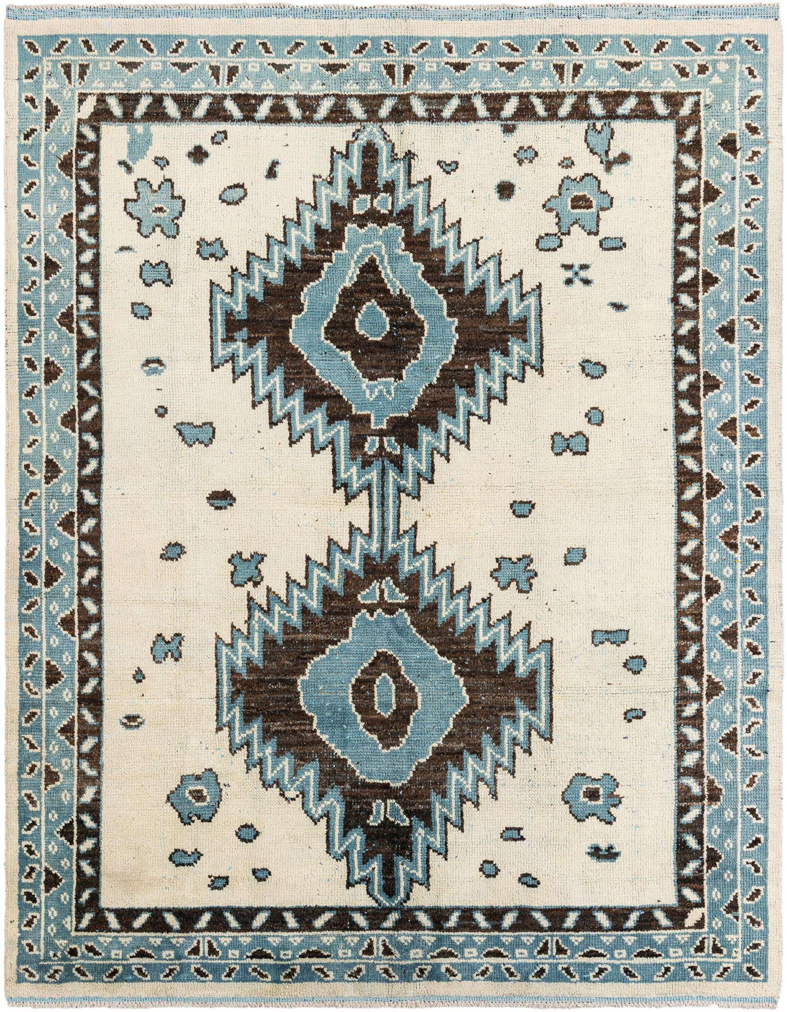 An 8x10 rectangular ivory wool shag rug with a large central blue and brown tribal medallion pattern, framed by a matching geometric border.
