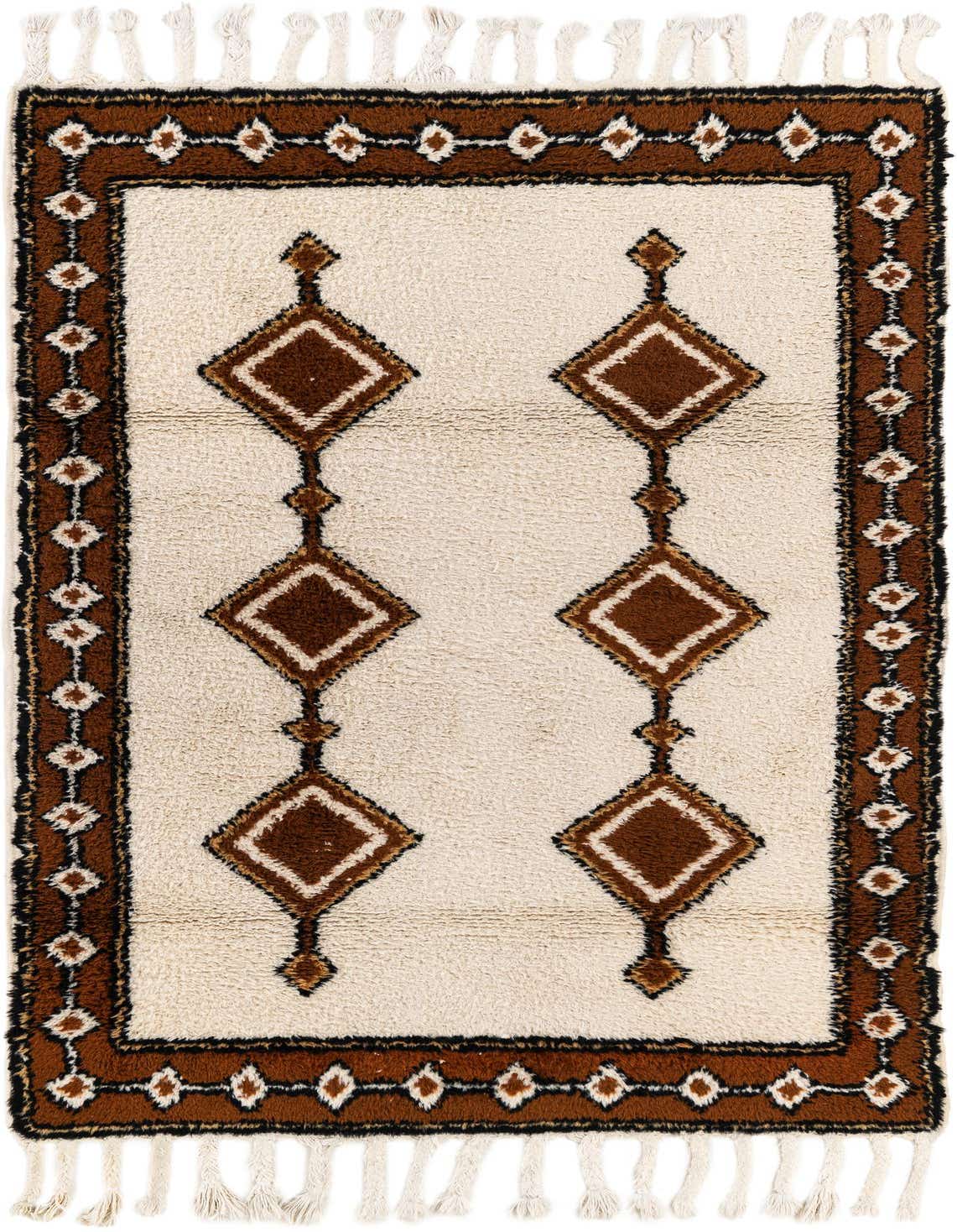 A 4x6 rectangular ivory shag rug with a brown tribal border and two vertical rows of brown diamond patterns.