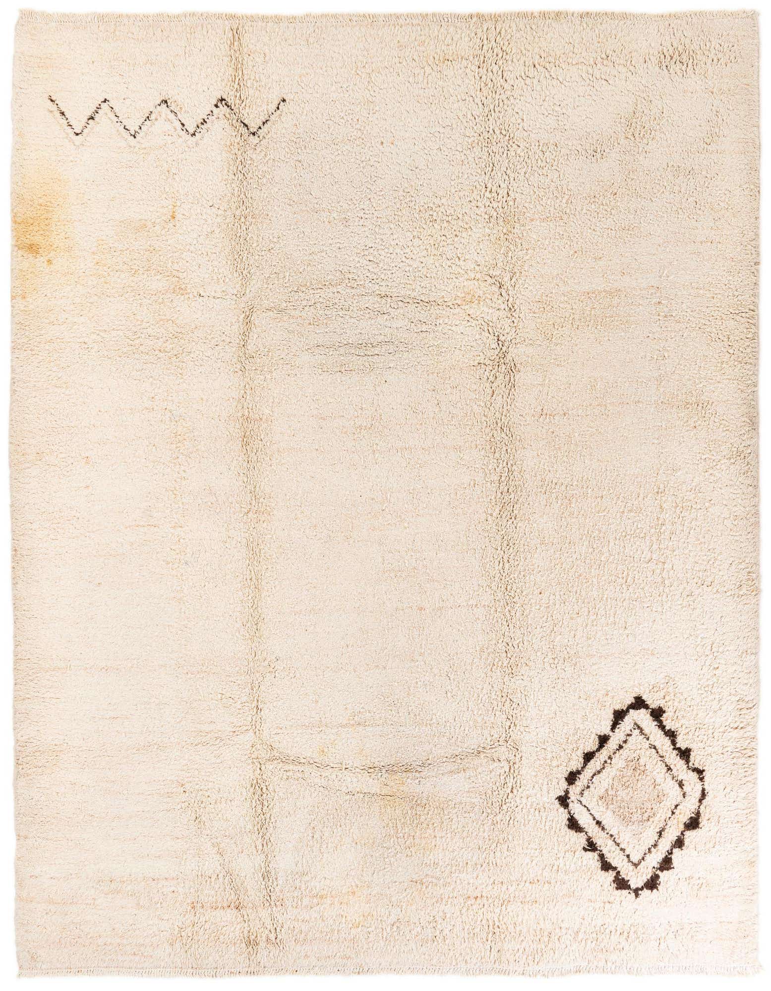 An 8x10 rectangular ivory shag rug with a brown zigzag pattern on the top left and a diamond motif on the bottom right.