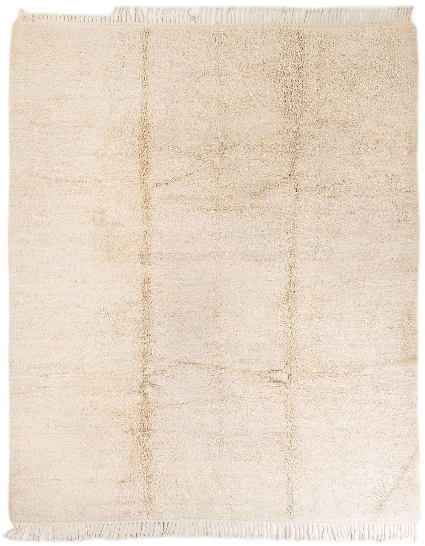 A rectangular 8x11 ivory shag rug with subtle tribal patterns and fringe, perfect for a living room.