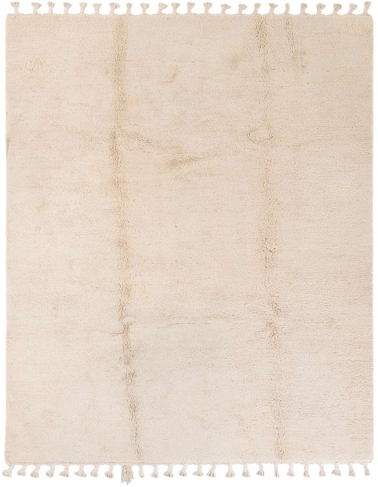 A 7x10 rectangular ivory shag rug with subtle tribal patterns and decorative tassels on the short ends, suitable for a living room.