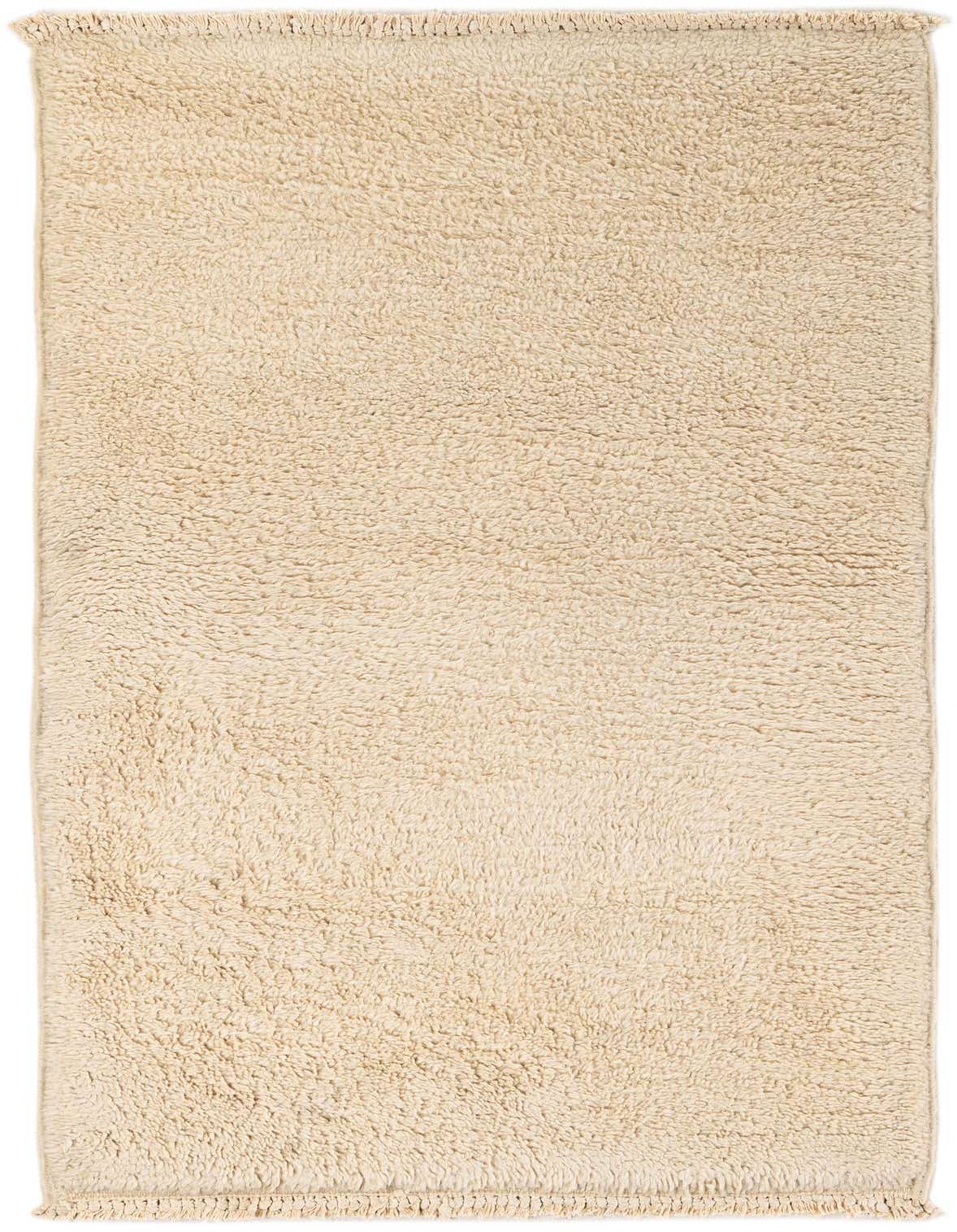 A 3x5 rectangular ivory shag rug with a thick, plush pile and subtle tribal texture, perfect for an indoor space.