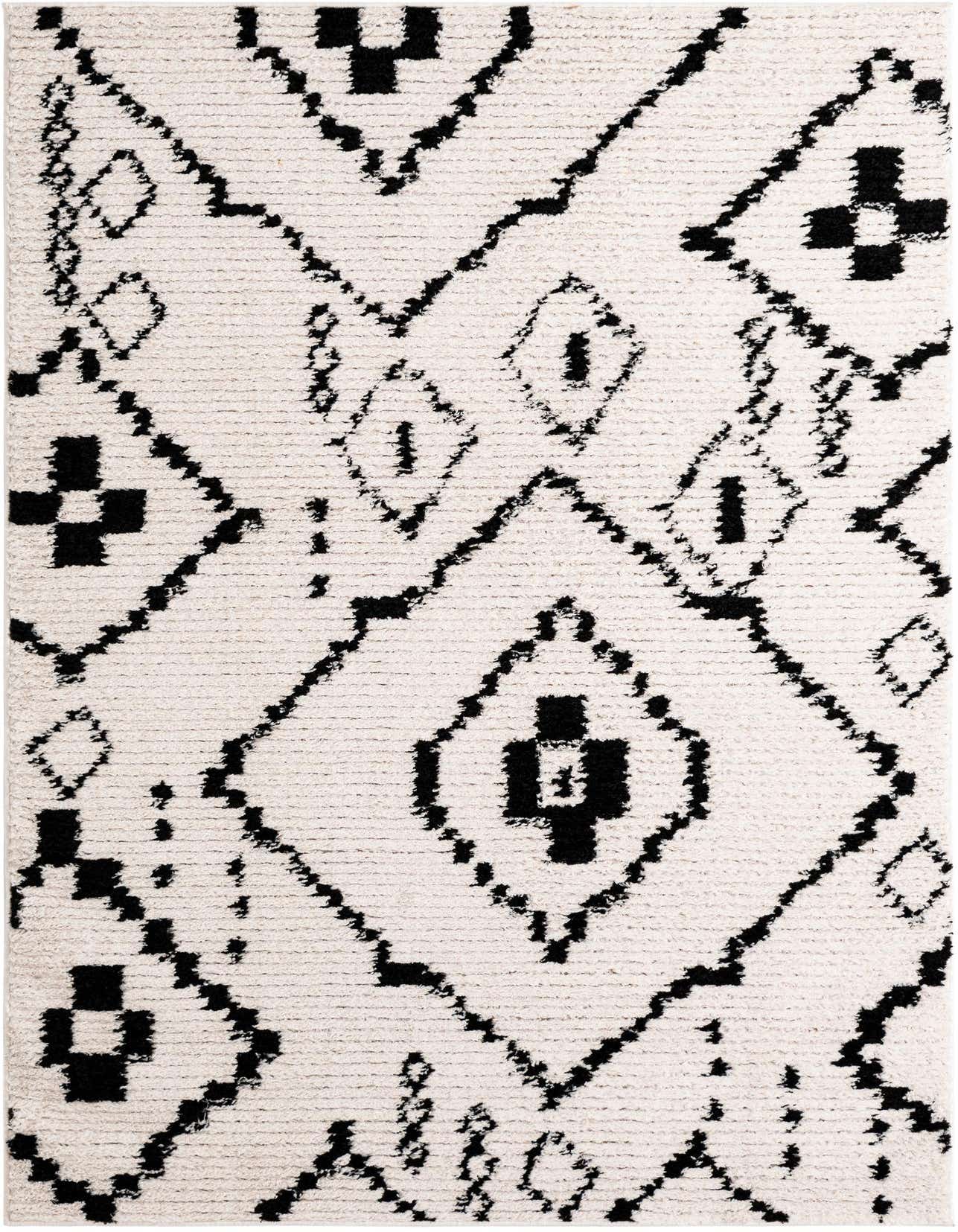 A close-up of a rectangular 5x8 ivory shag rug with a bold black tribal geometric pattern, perfect for a living room.