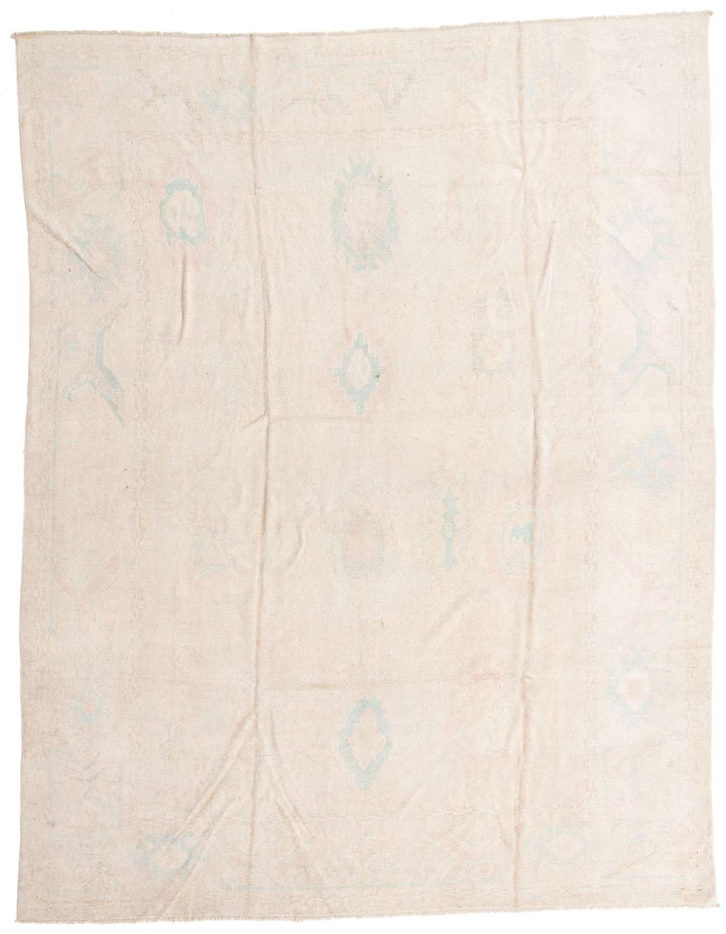 A 10x13 rectangular ivory wool rug with subtle light blue traditional and abstract patterns, handmade for indoor use.