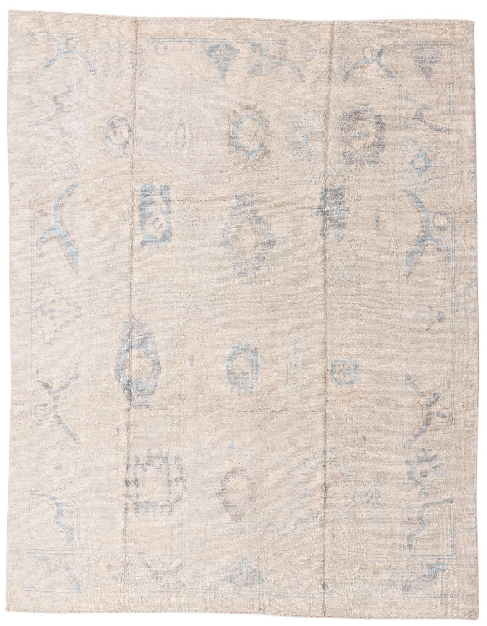 A 9x11 rectangular ivory wool Oushak rug with subtle abstract traditional patterns in light blue and grey.