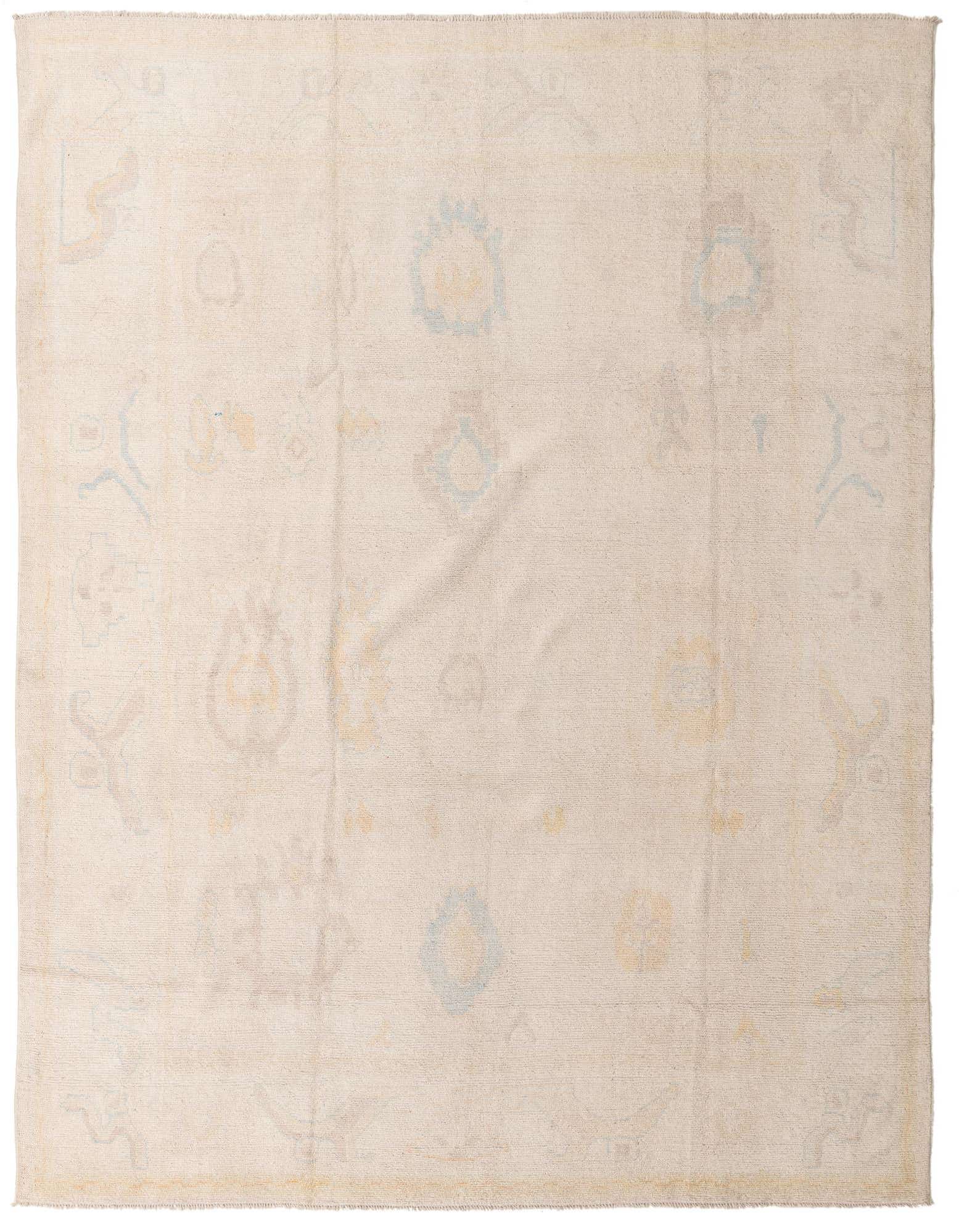 A 9x12 rectangular ivory wool Oushak rug with subtle abstract patterns in muted blues and yellows.
