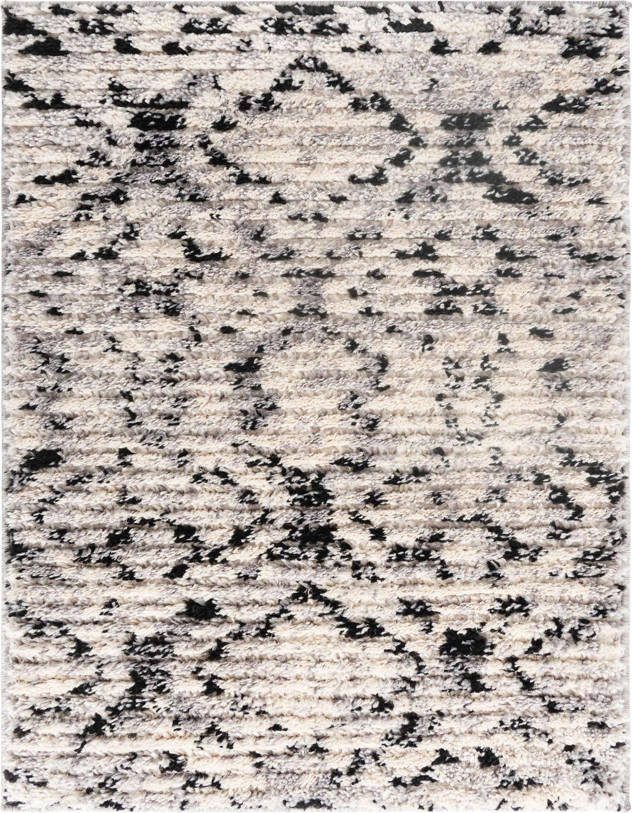 A close-up of a rectangular 2x3 ivory shag rug with a modern striped pattern and textured black accents.