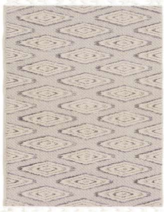 A 12 ft runner rug with an ivory and cream background, featuring a modern tribal trellis pattern in varying shades of white and gray, with tassels on the ends.